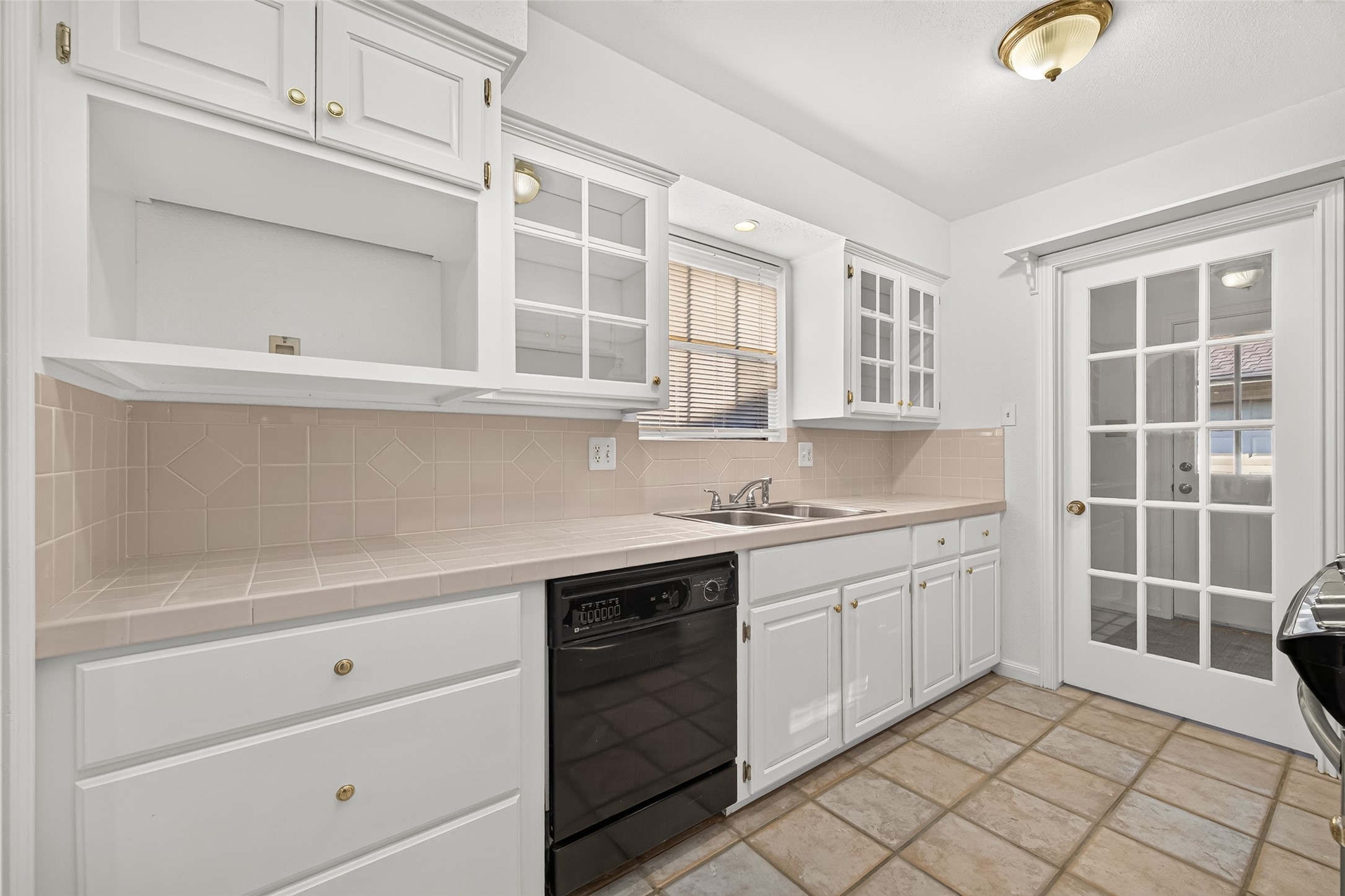 Functional kitchen featuring white custom cabinetry and generous counter space.