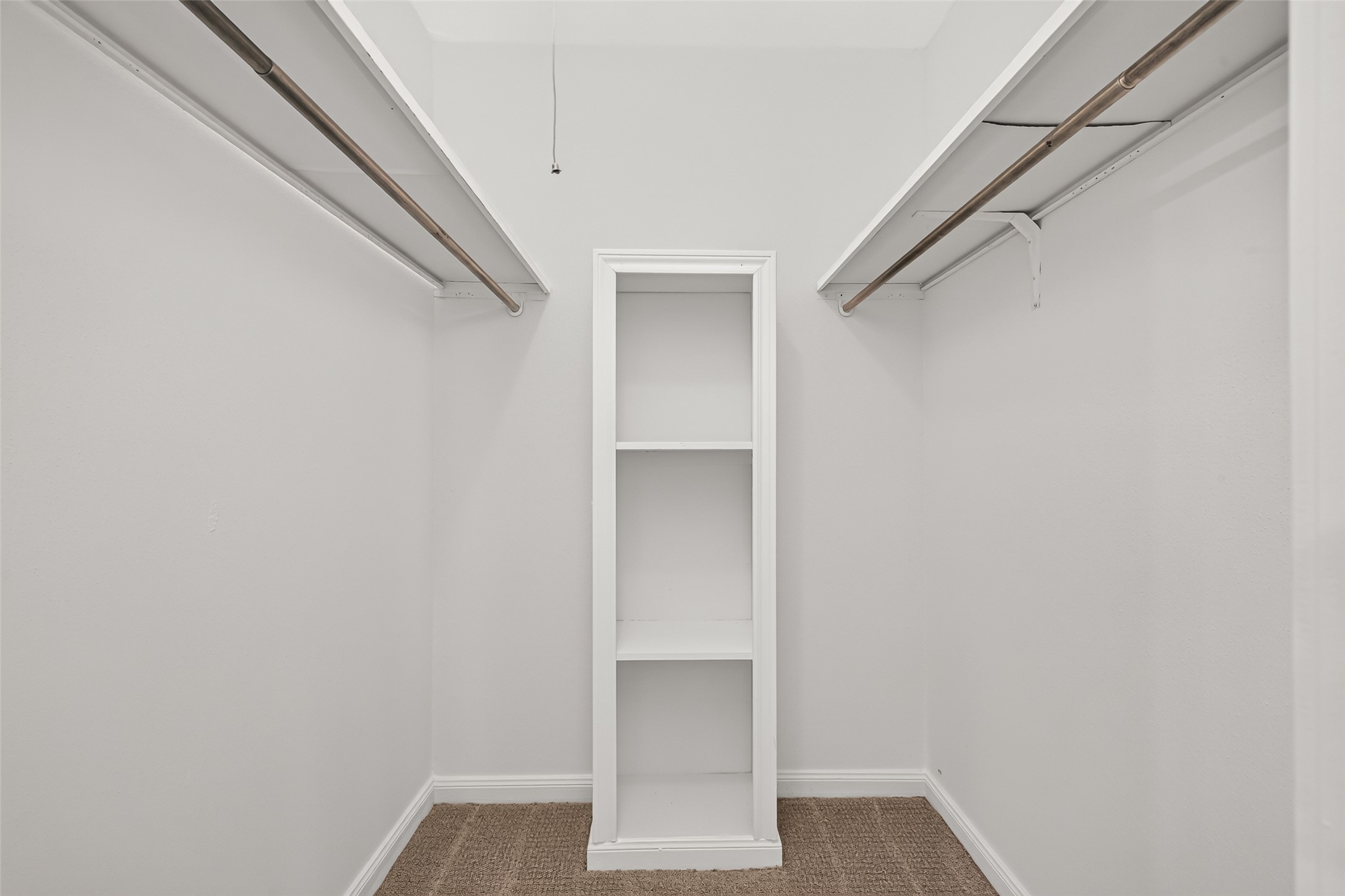 Spacious primary walk-in closet featuring a practical layout with plenty of room for clothing, shoes, and accessories.