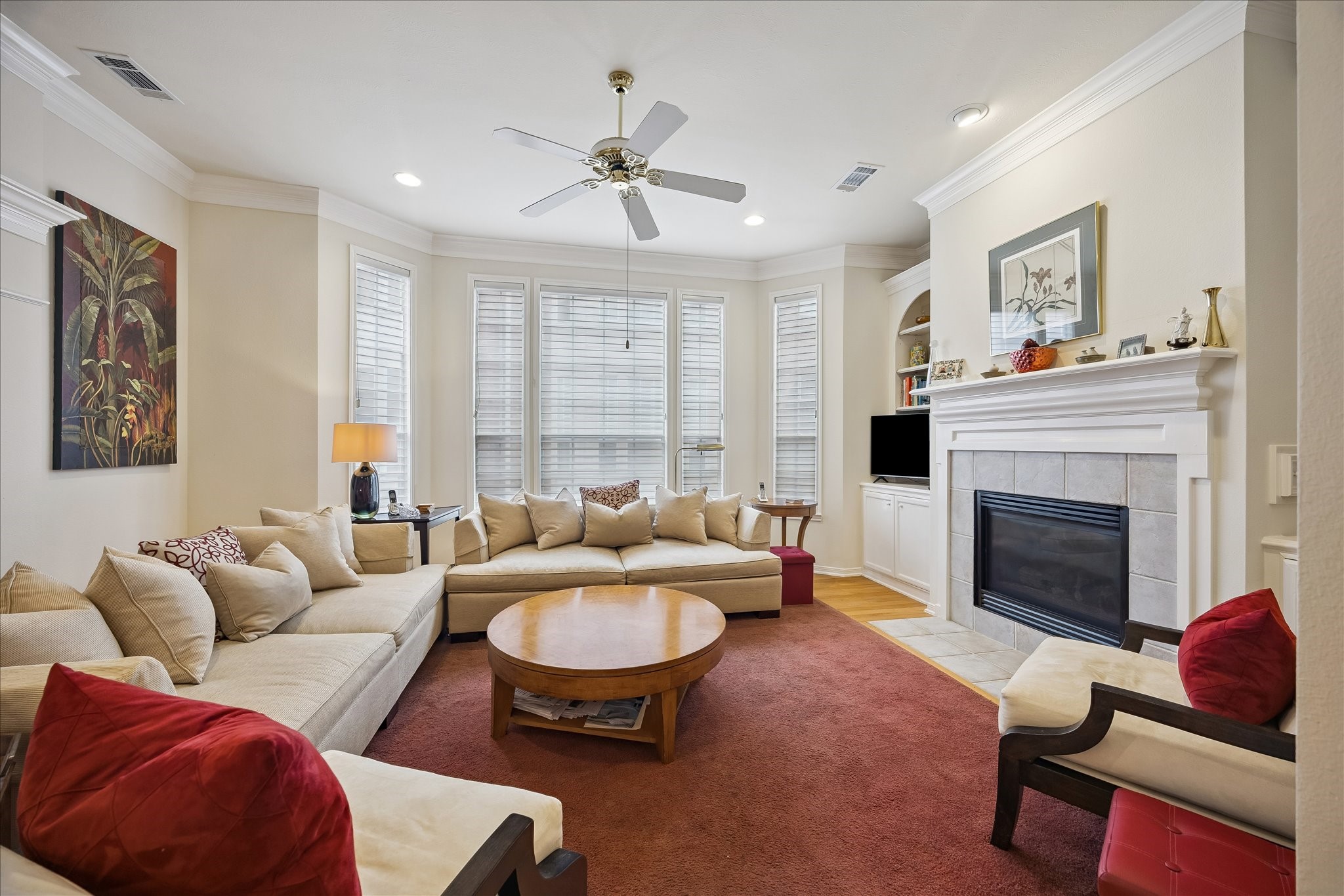 Spacious living room w/ fireplace and built-ins beside fireplace.