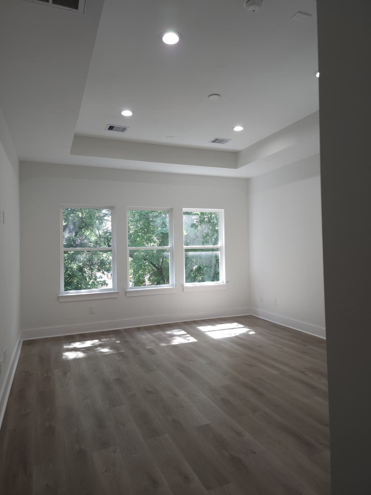 PRIMARY BEDROOM HAS RAISED CEILING AND TONS OD NATURAL LIGHT