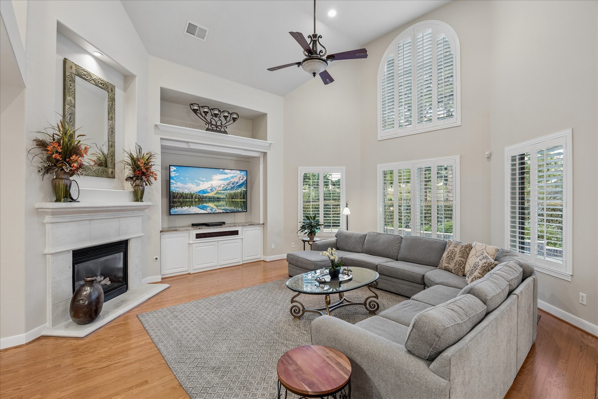 Spacious family room with a tall vaulted ceiling, built-in cabinetry, and a wall of windows overlooking the private backyard and sparkling pool. Spacious family room with a tall vaulted ceiling, built-in cabinetry, and a wall of windows overlooking the private backyard and sparkling pool.