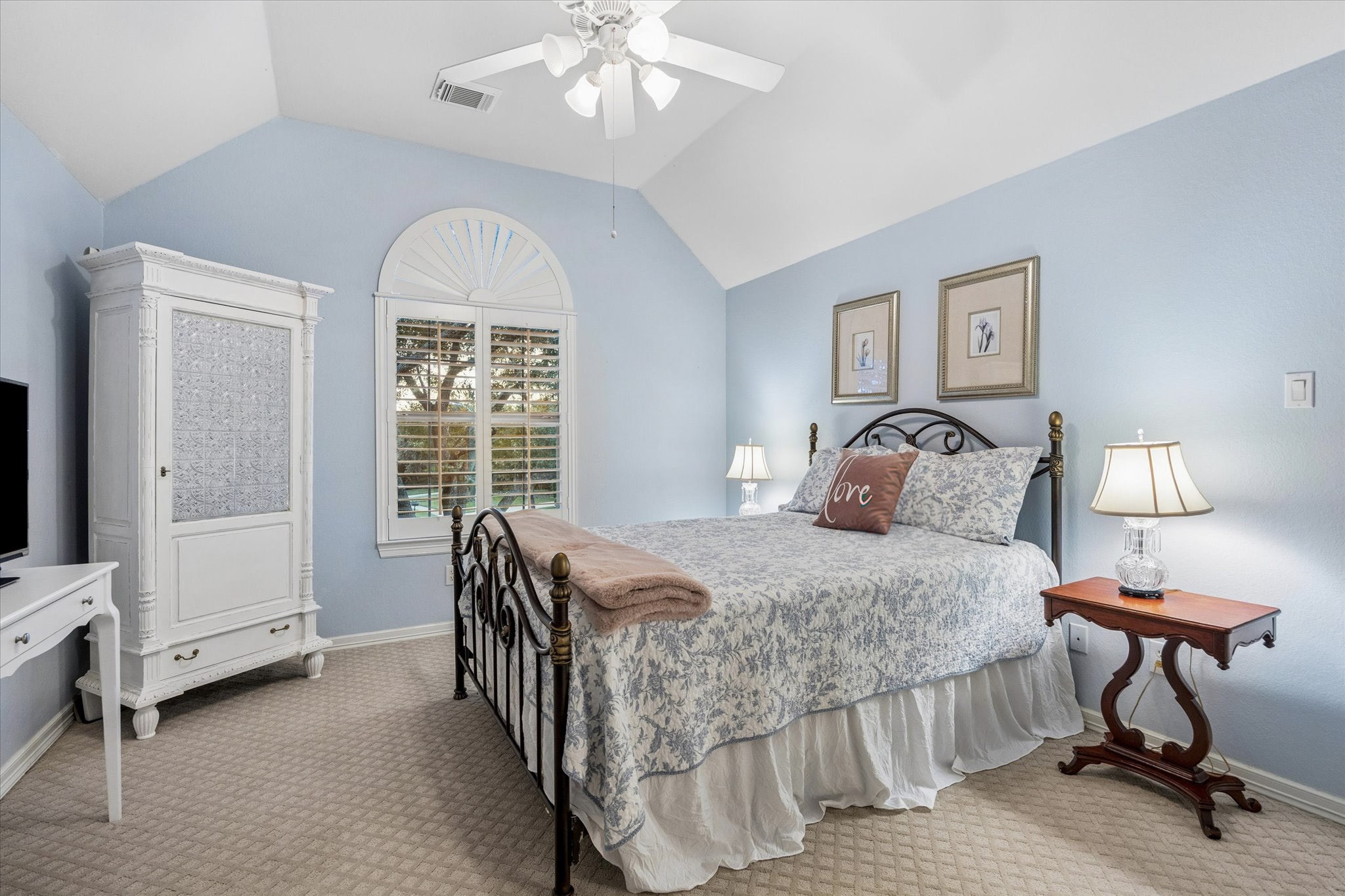 This front facing bedroom has vaulted ceilings with fan, closet, and personal vanity.