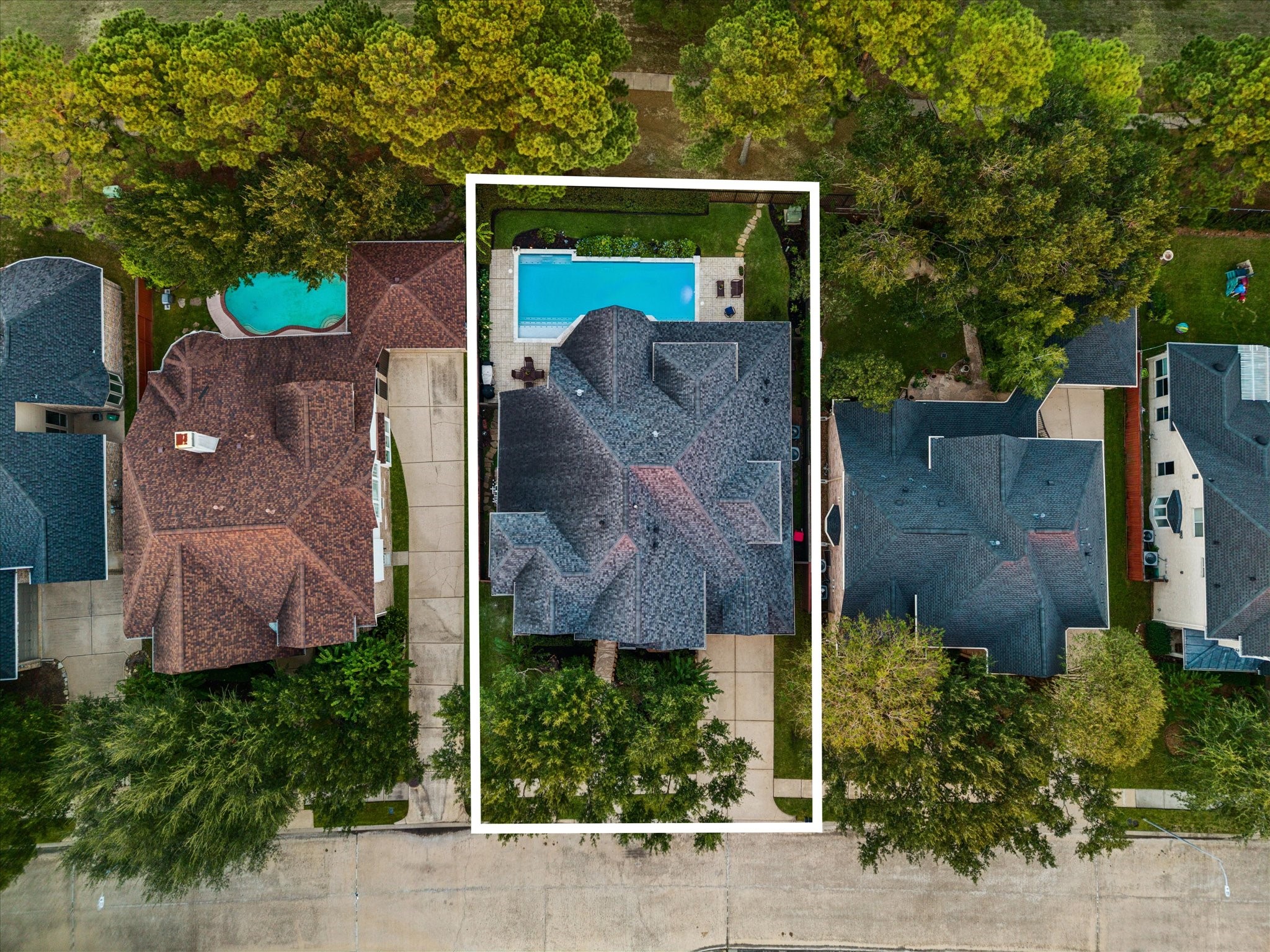 An impressive aerial view showcases the homes inviting setting, surrounded by mature trees and lush landscaping that enhance its curb appeal and create a beautiful sense of privacy.