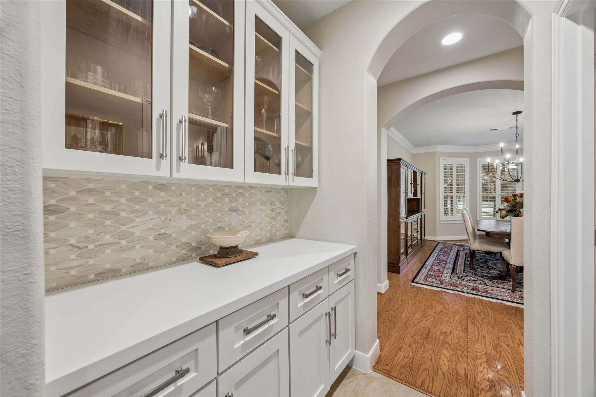 This butlers pantry is a beautiful pass between the dining room and kitchen. Glass front cabinets to showcase your China or glassware. The powder room is just opposite.