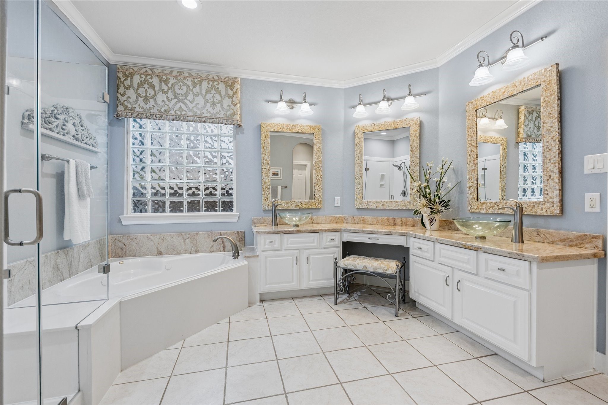 Getting ready or winding down feels effortless with dual vanities, a dedicated seated vanity, and a walk in closet.