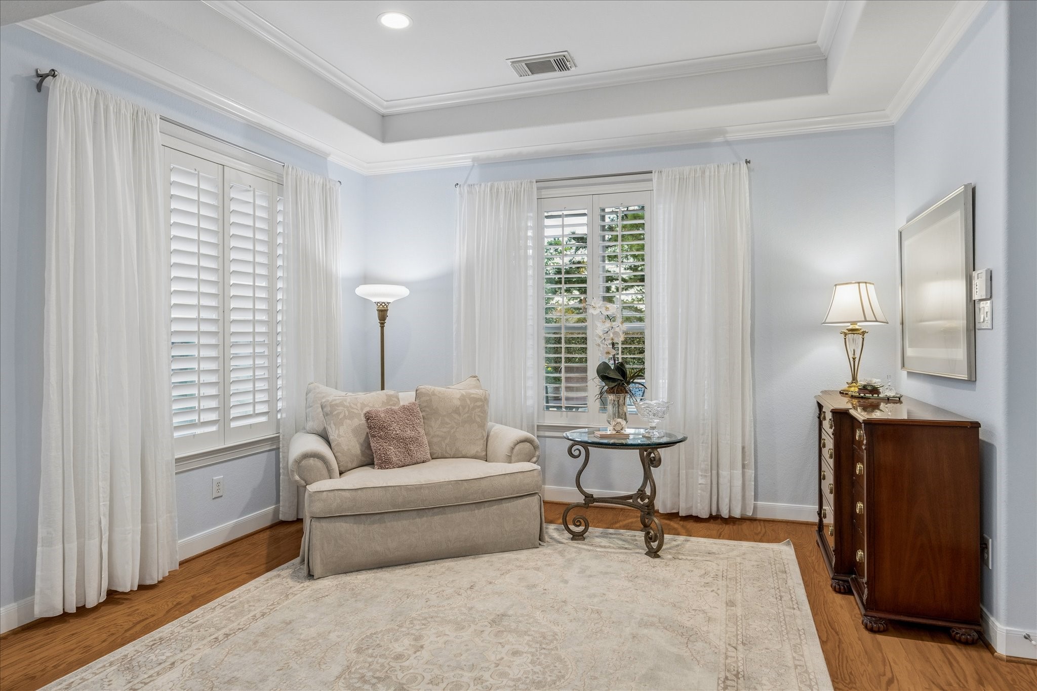 A true retreat, the primary suite features a well-lit sitting area that offers a quiet space to unwind.