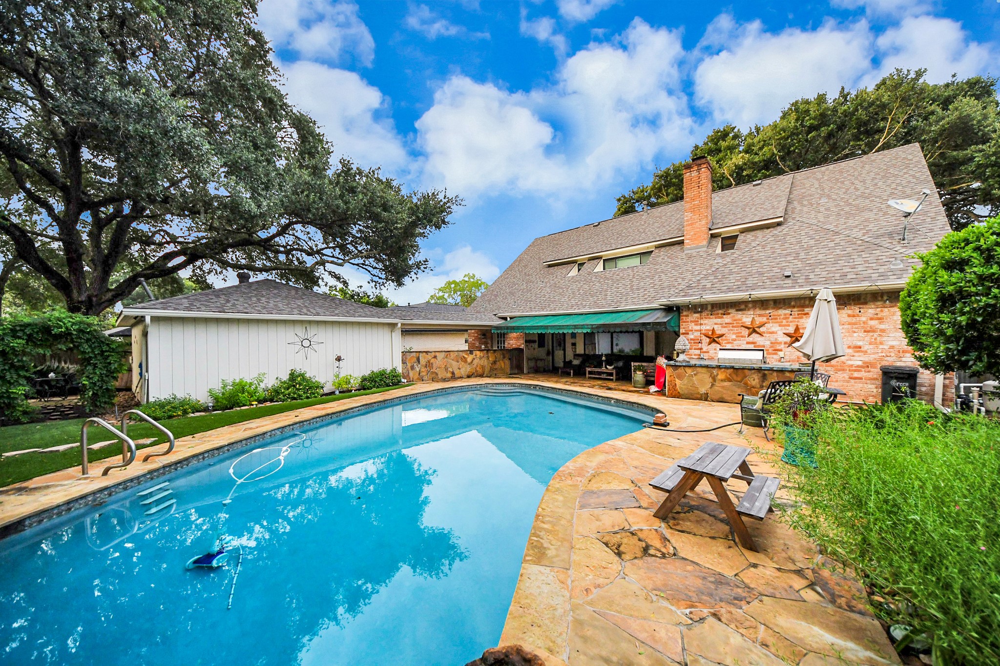 An expansive pool deck, covered patio and outdoor kitchen create plenty of space for entertaining.