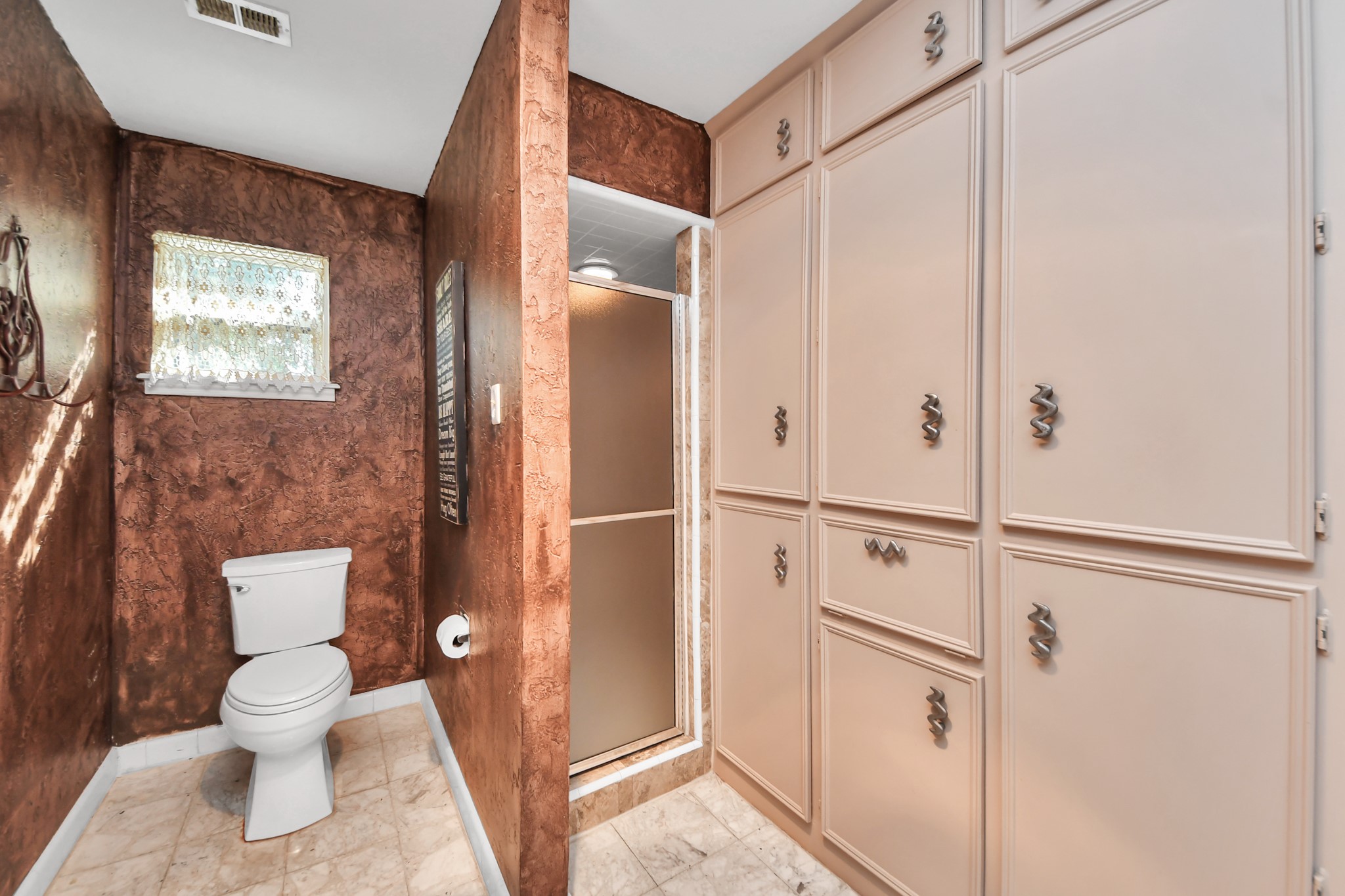 Built-in cabinetry provides exceptional storage in the secondary bathanother example of the thoughtful storage found throughout the home.