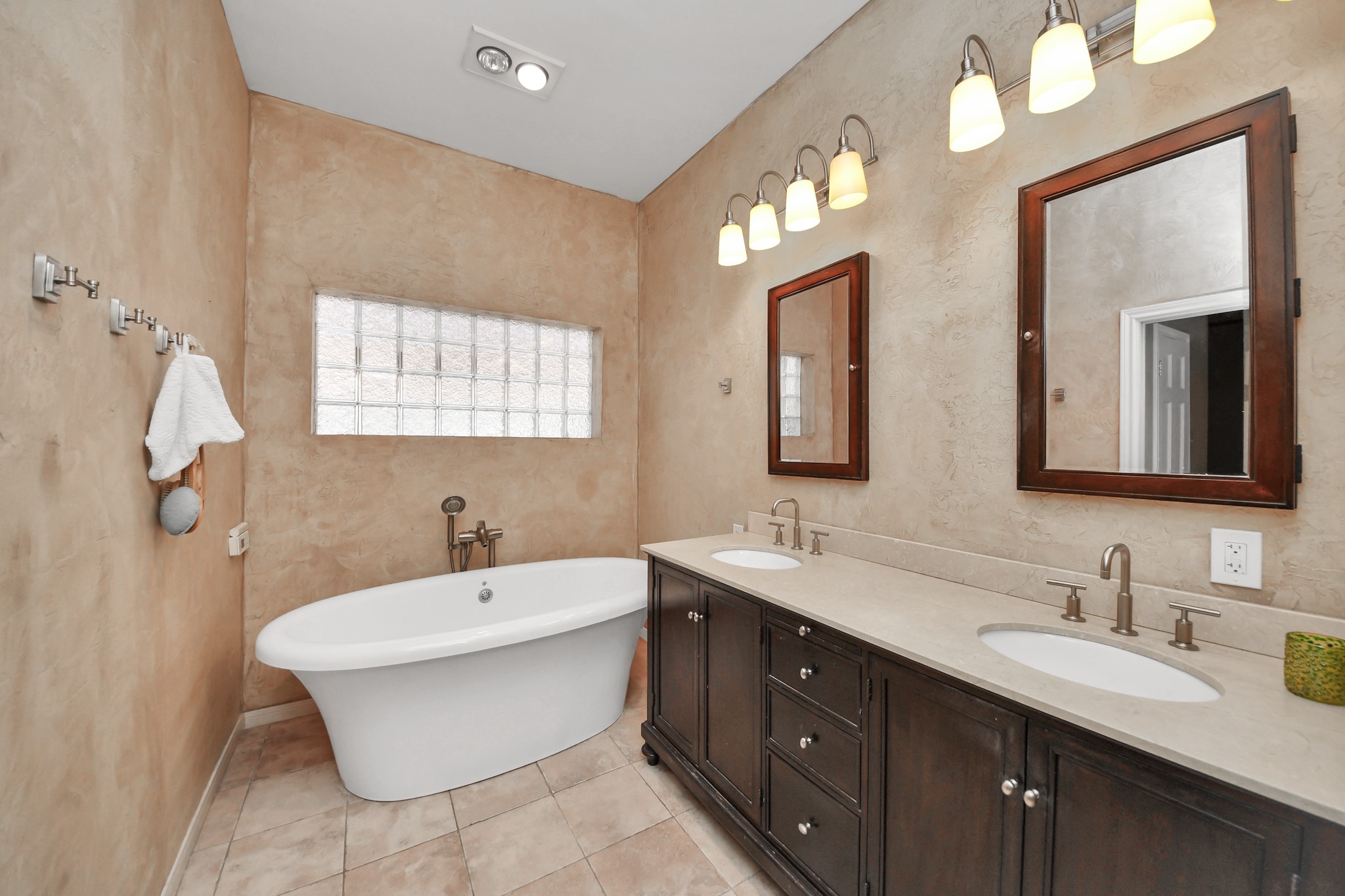 Primary bath has already seen meaningful updates, including a freestanding soaking tub and dual-sink vanity.
