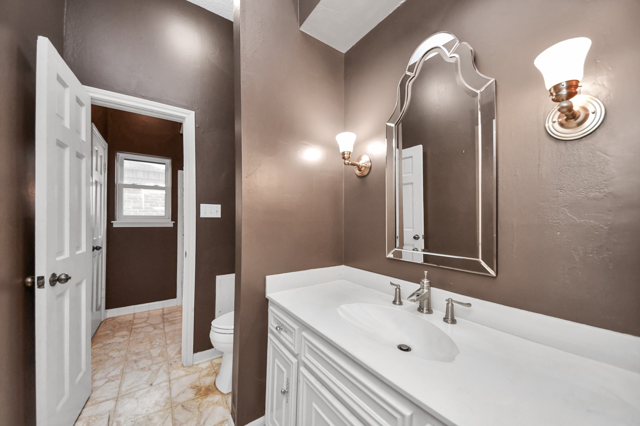Another secondary full bath downstairs offers vanity, generous counter space and a separate water closet.