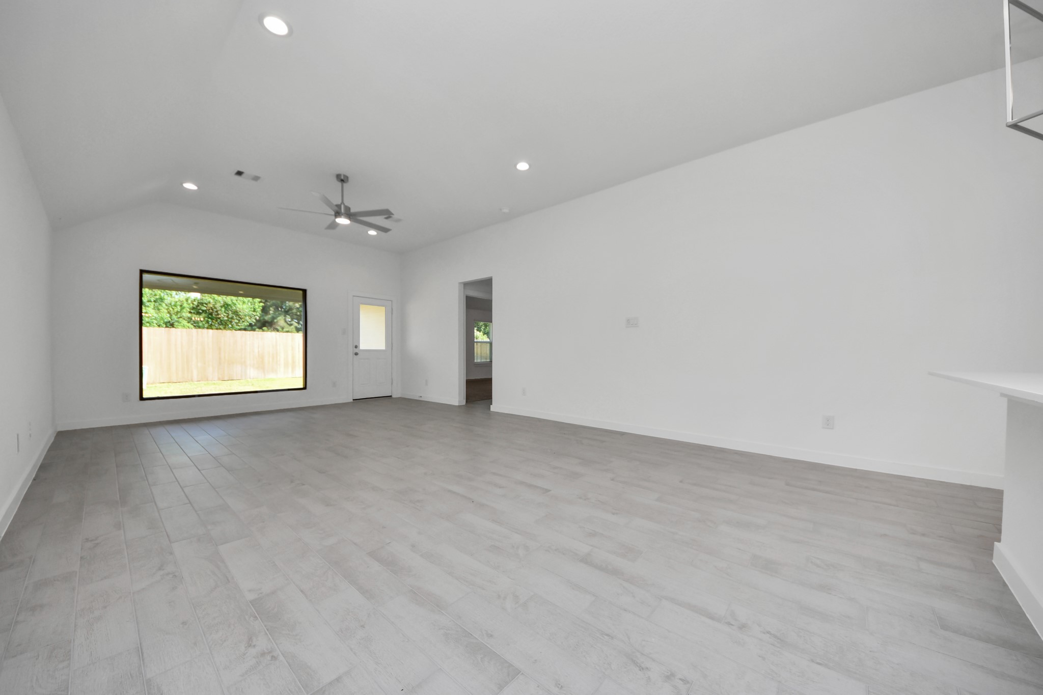 Gather the family and guests together in your lovely living room! Featuring soaring high ceilings, recessed lighting, ceiling fan, custom paint, gorgeous floors, and large windows that provide plenty of natural lighting throughout the day. Sample photo of completed home with similar floor plan. Actual colors and selections may vary.