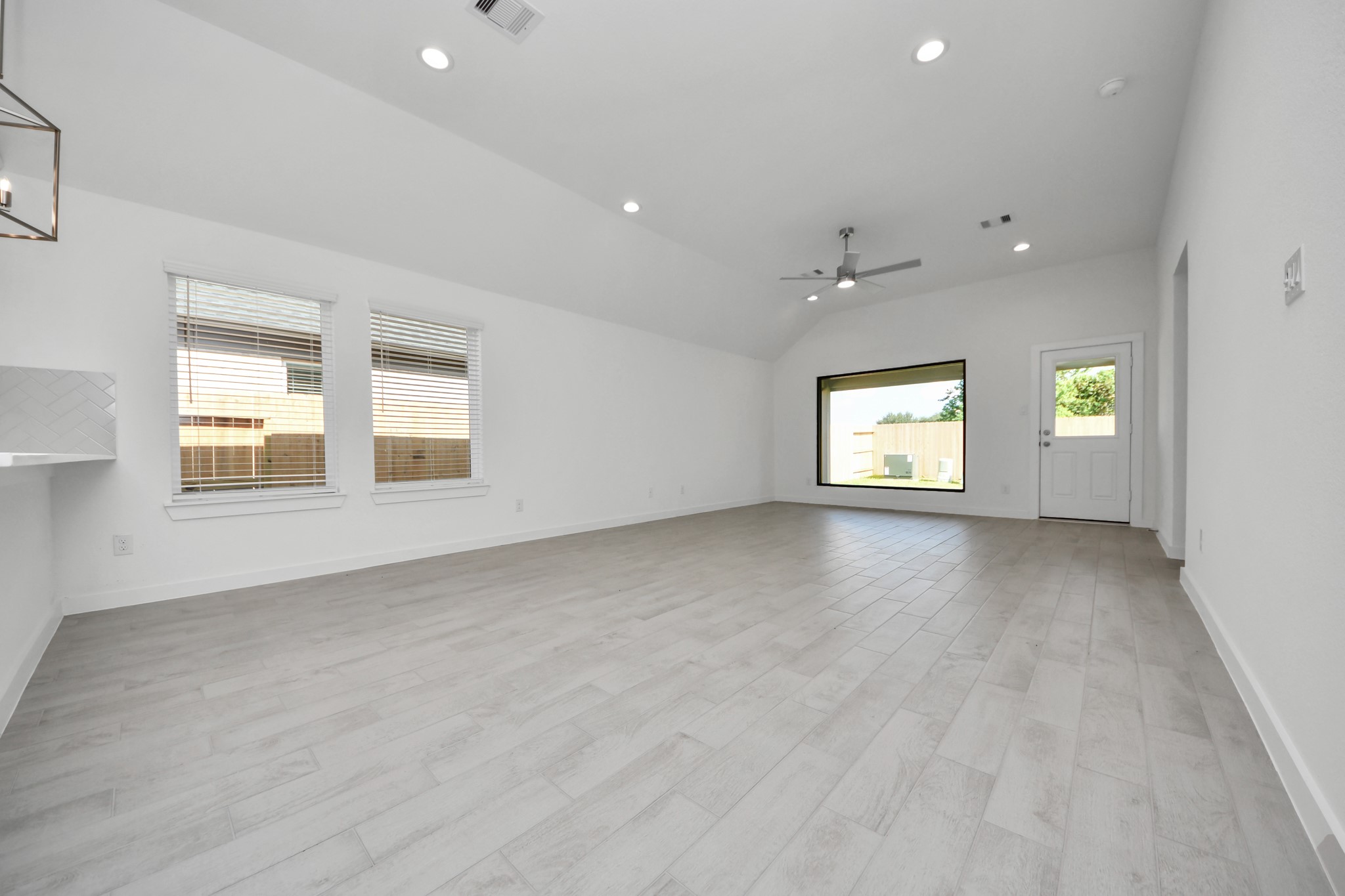 Welcome family and guests to your charming living room! With its high ceilings, recessed lighting, ceiling fan, custom paint, beautiful flooring, and large windows that let in abundant natural light, this room is perfect for gatherings. Sample photo of completed home with similar floor plan. Actual colors and selections may vary.