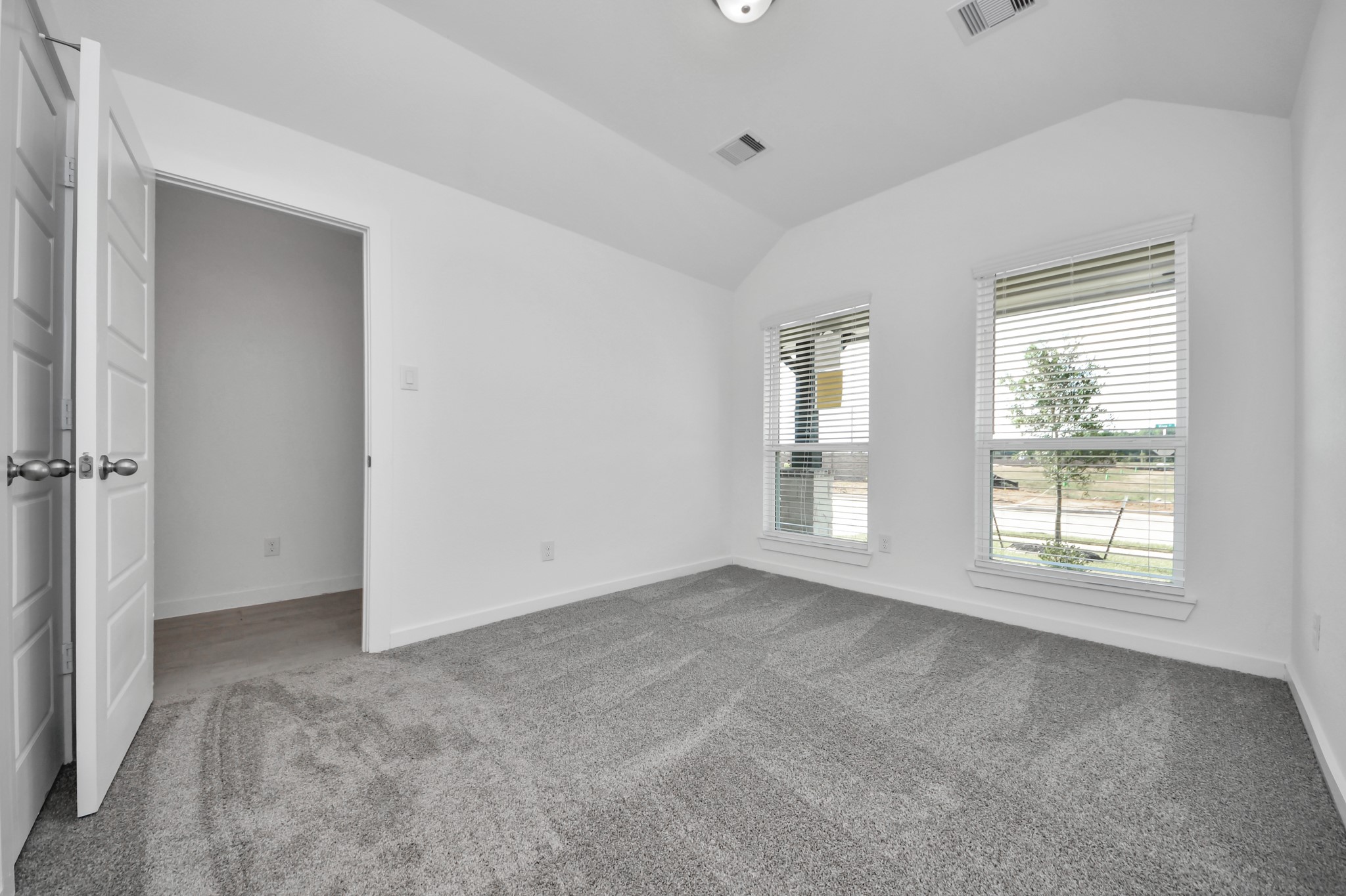 Generously sized secondary bedrooms featuring spacious closets, soft and inviting carpeting underfoot, large windows allowing plenty of natural light, and the added touch of privacy blinds for your personal retreat. Sample photo of completed home with similar floor plan. Actual colors and selections may vary.