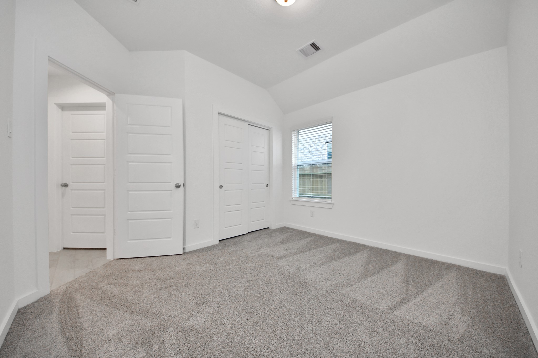 Generously sized secondary bedrooms featuring spacious closets, soft and inviting carpeting underfoot, large windows allowing plenty of natural light, and the added touch of privacy blinds for your personal retreat. Sample photo of completed home with similar floor plan. Actual colors and selections may vary.