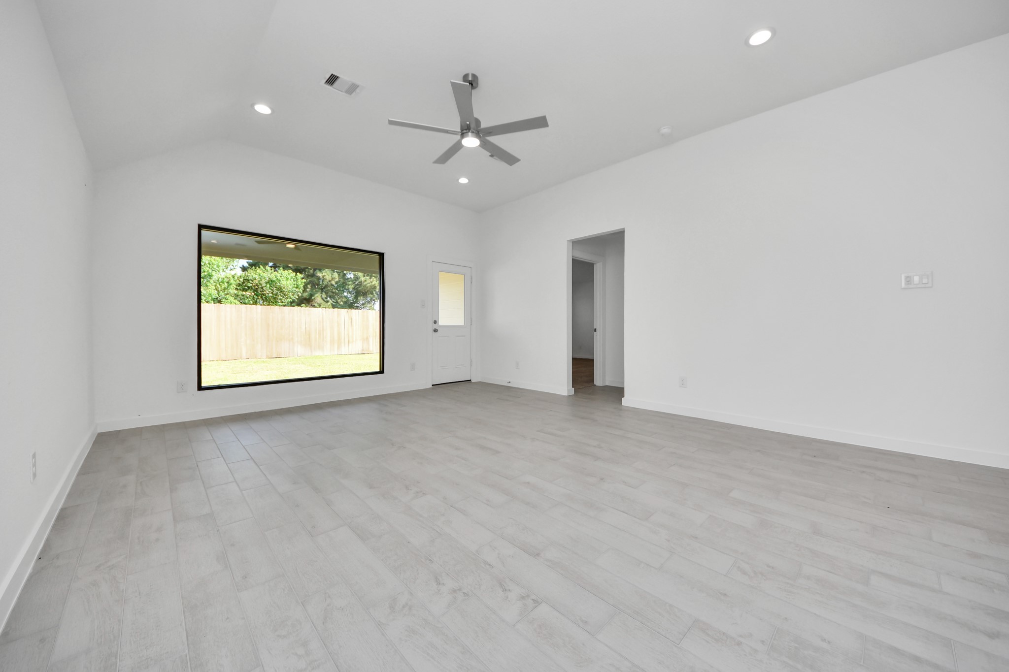 Relax and unwind in this inviting family room, illuminated by abundant natural light streaming in through tall windows, complemented by high ceilings and stunning flooring. Stay comfortable year-round with the gentle breeze from the ceiling fan, creating the perfect atmosphere for family gatherings. Sample photo of completed home with similar floor plan. Actual colors and selections may vary.
