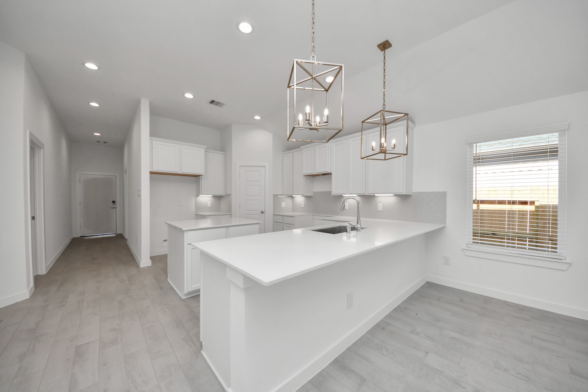 This kitchen is truly a chef's dream! This haven Boasts high ceilings, recessed & pendant lighting, stained wood cabinets, granite countertops, stainless steel appliances, a modern tile backsplash.  All of this overlooks your expansive family room, creating a perfect space for culinary delights and family gatherings. Sample photo of completed home with similar floor plan. Actual colors and selections may vary.
