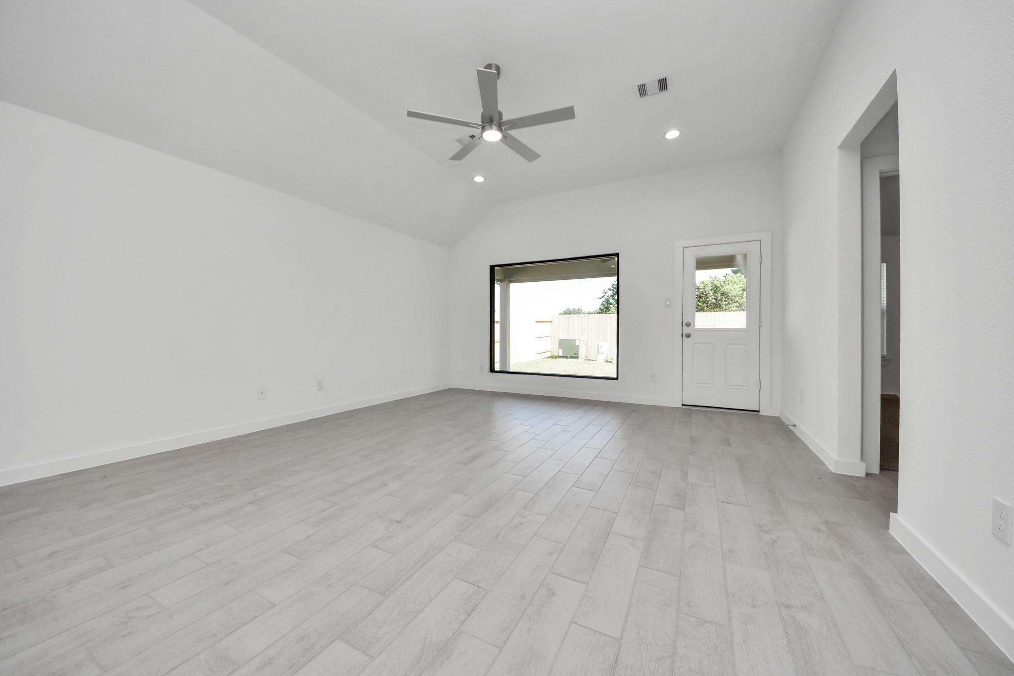 Family room flooded with natural light through the expansive windows.  The premium tile flooring adds a touch of luxury to the space, creating the perfect setting for relaxing moments and cherished gatherings with loved ones. Sample photo of completed home with similar floor plan. Actual colors and selections may vary.