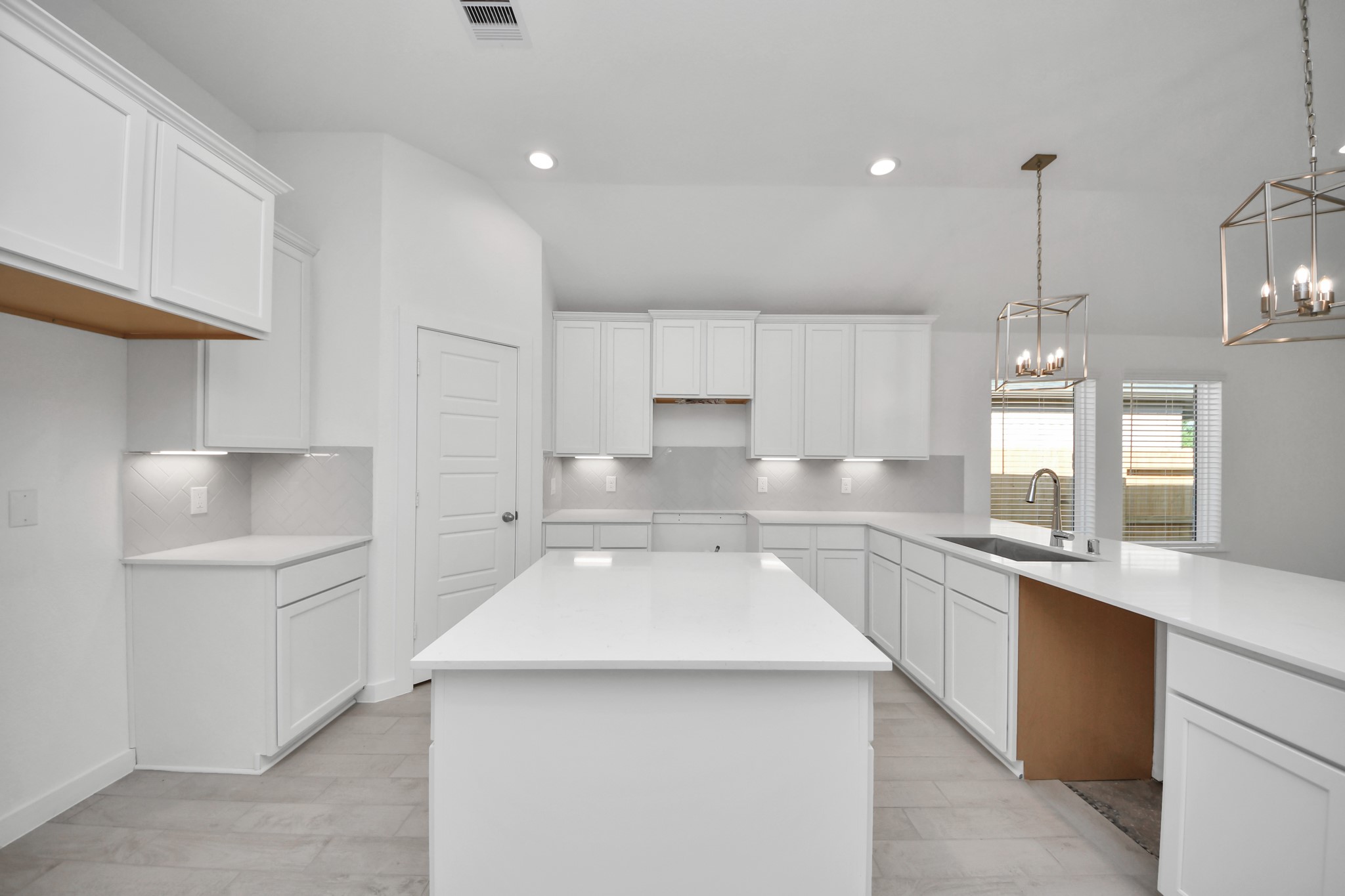 This kitchen is by far any chefs dream! This spacious kitchen features high ceilings, light stained wood cabinets, granite countertop, SS appliances, modern tile backsplash, recessed lighting, extended counter space, granite kitchen island, and space for breakfast bar, and a walk-in pantry all overlooking your huge family room. Sample photo of completed home with similar floor plan. Actual colors and selections may vary.