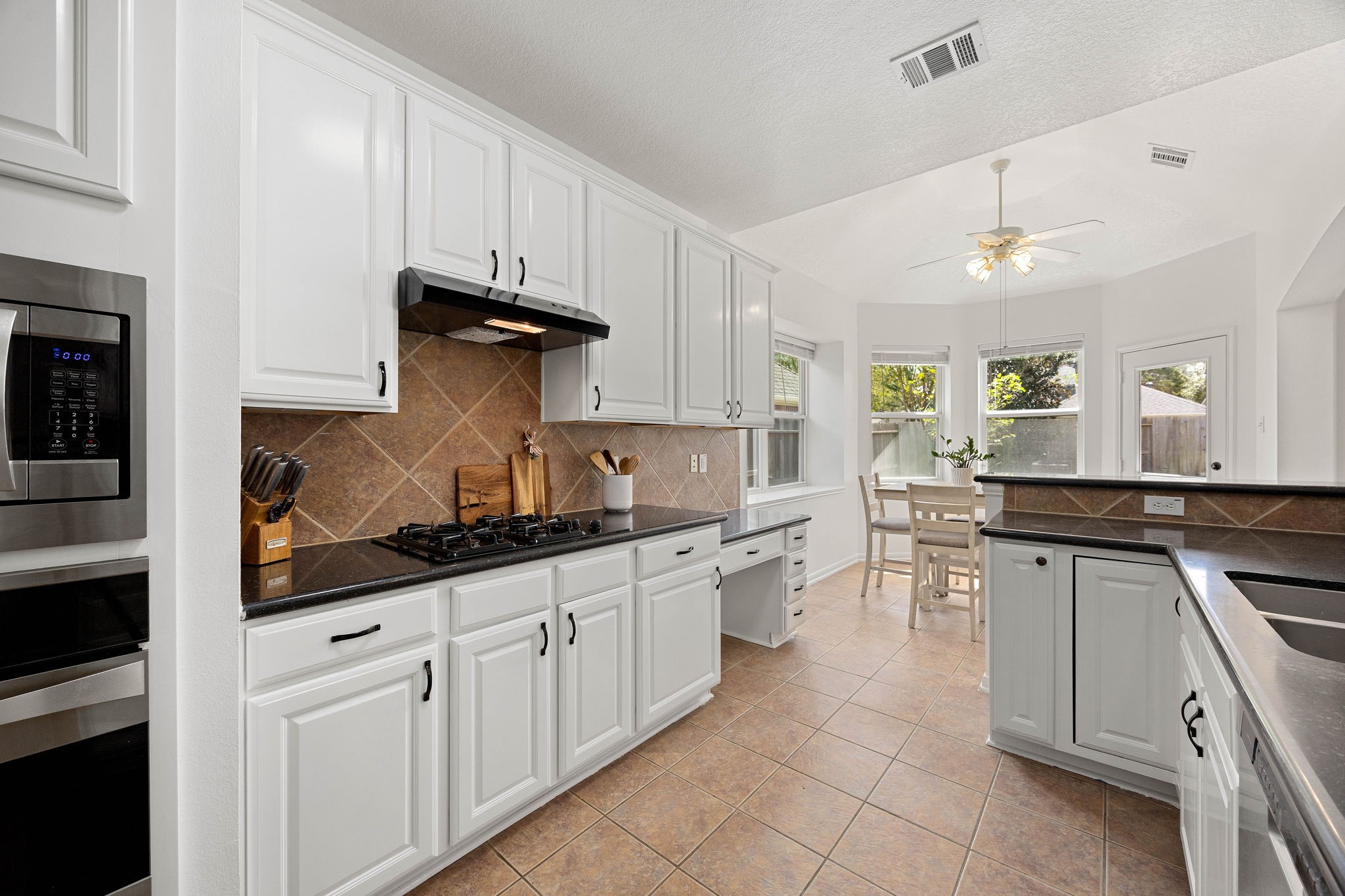 Additional kitchen view showcasing the generous workspace, abundant storage, and open connection to the breakfast area.