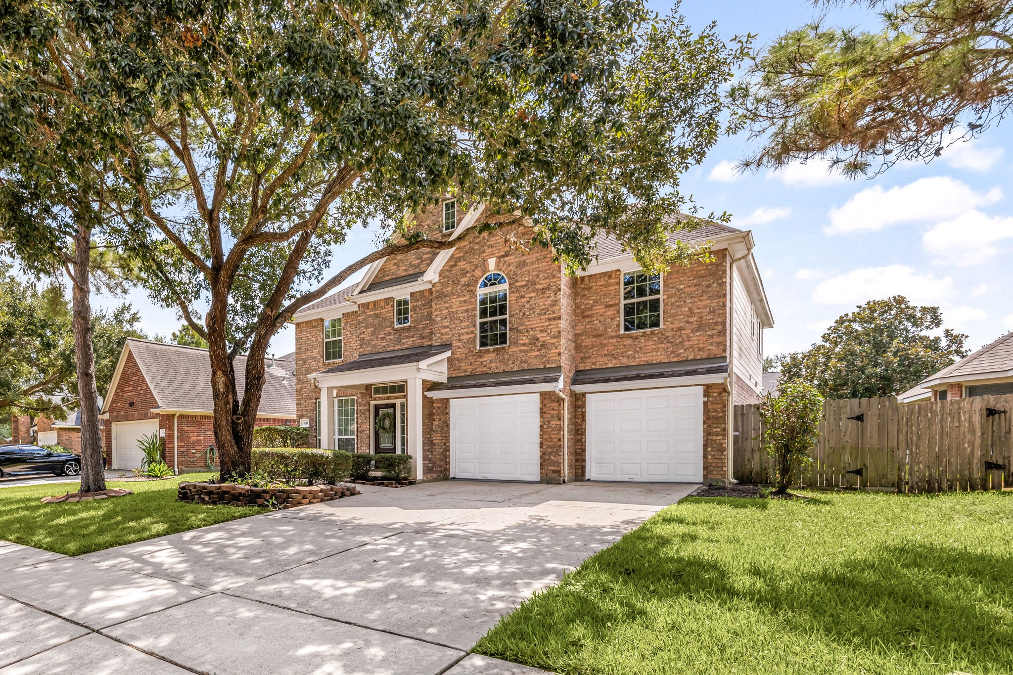 Additional front exterior view showcasing the homes two-story design, shaded front lawn, and covered entry.