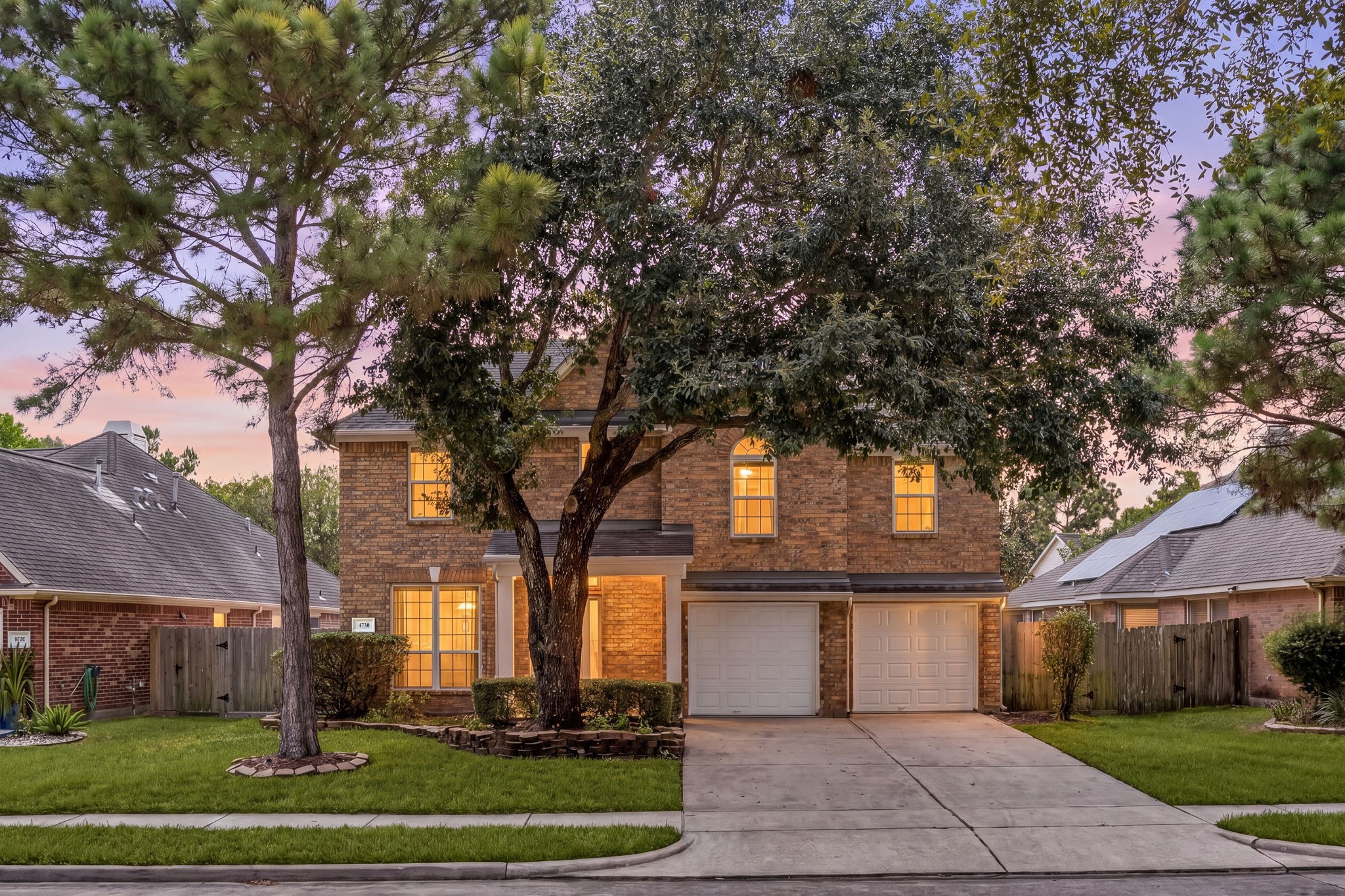 Welcoming two-story exterior featuring mature shade trees, an attached two-car garage, and an inviting front entry. Welcoming two-story exterior featuring mature shade trees, an attached two-car garage, and an inviting front entry.
