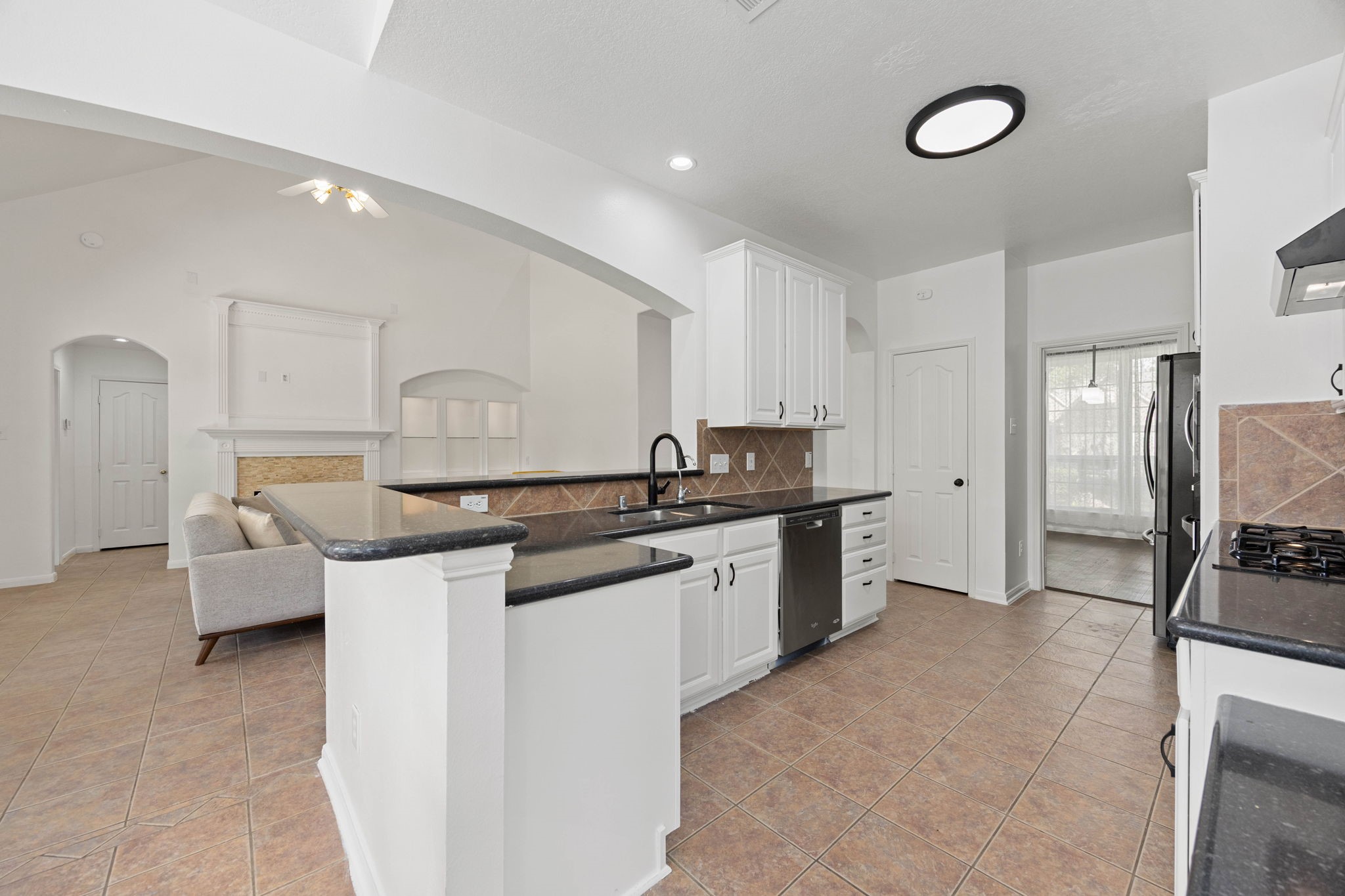 Spacious kitchen featuring extensive cabinetry, generous counter space, a breakfast bar, and an open layout.