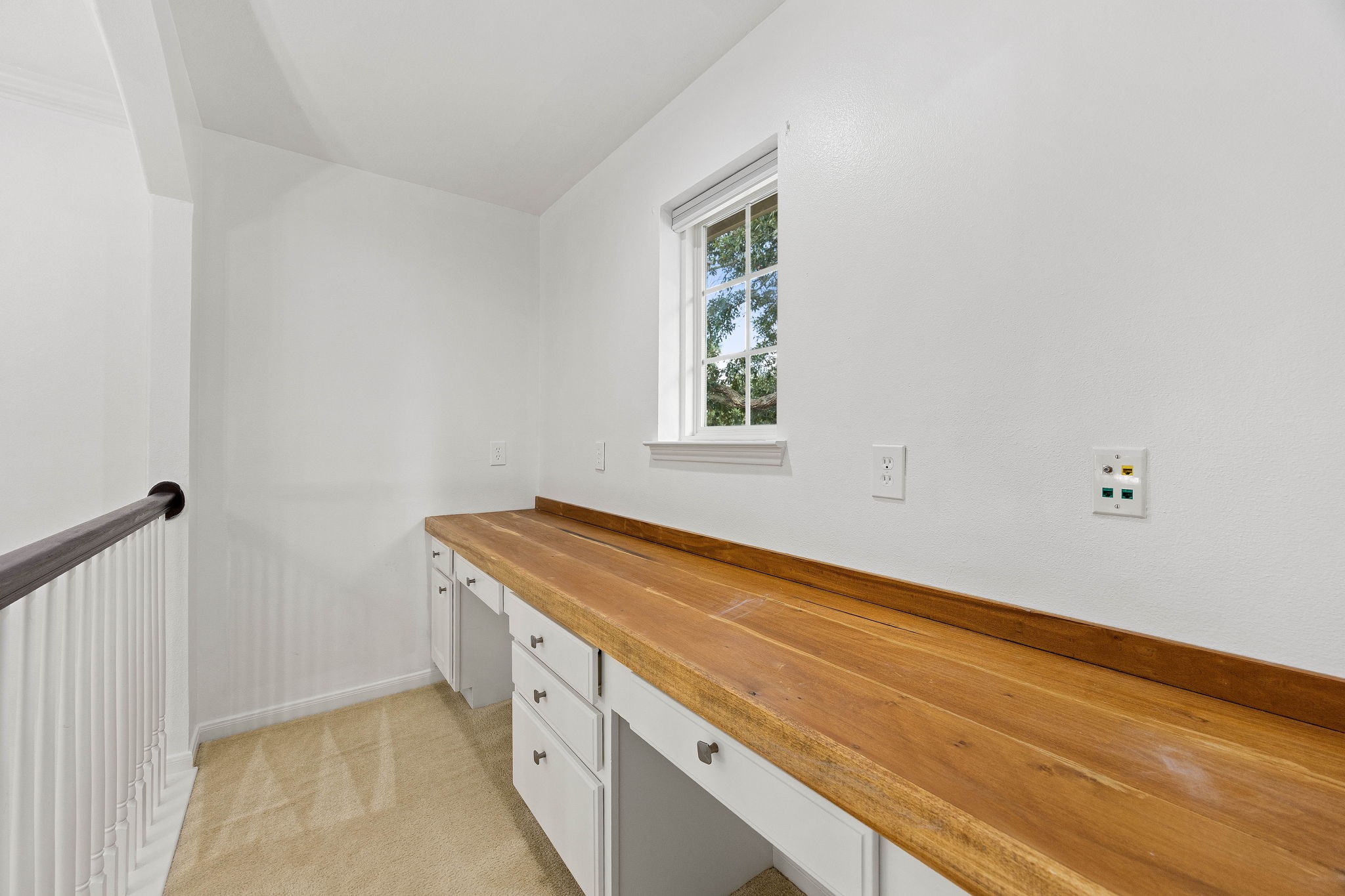 Built-in workspace featuring a generous desktop, cabinetry, and convenient storage for a home office or study area.