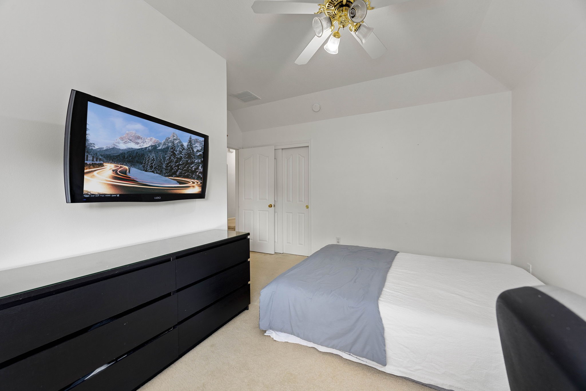 Secondary bedroom offering natural light, a ceiling fan, and flexible space for family members or guests.