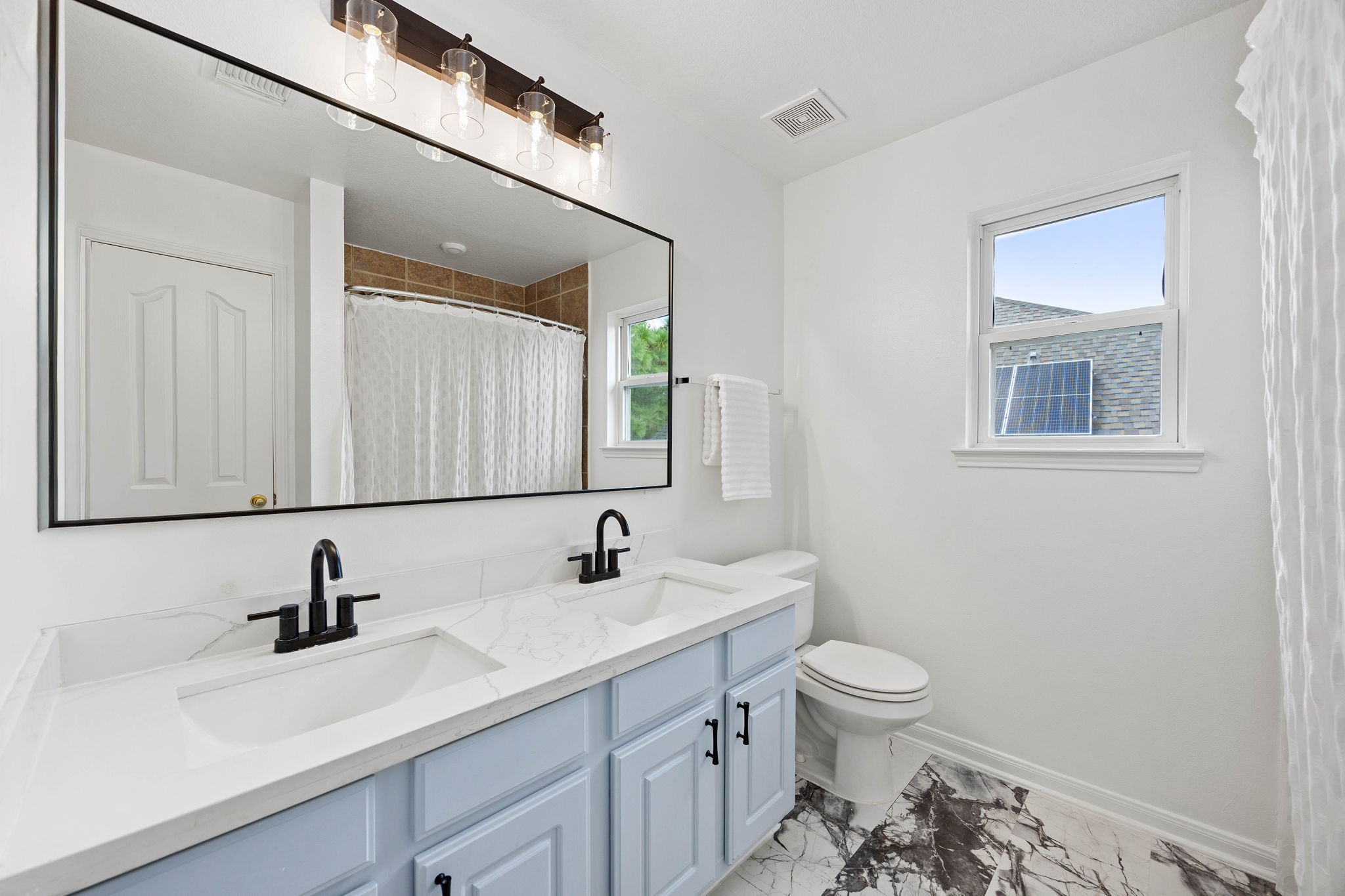 Secondary full bathroom featuring a spacious vanity, cabinet storage, and a tub-and-shower combination.