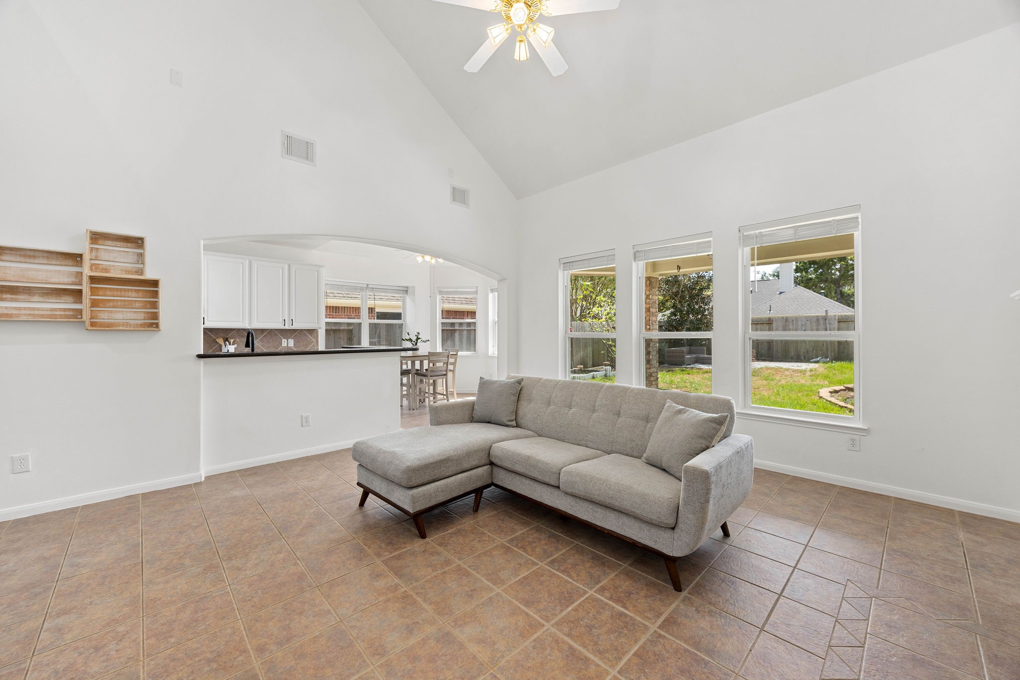 Bright family room with a fireplace, large windows, and plenty of space for comfortable seating and entertaining.
