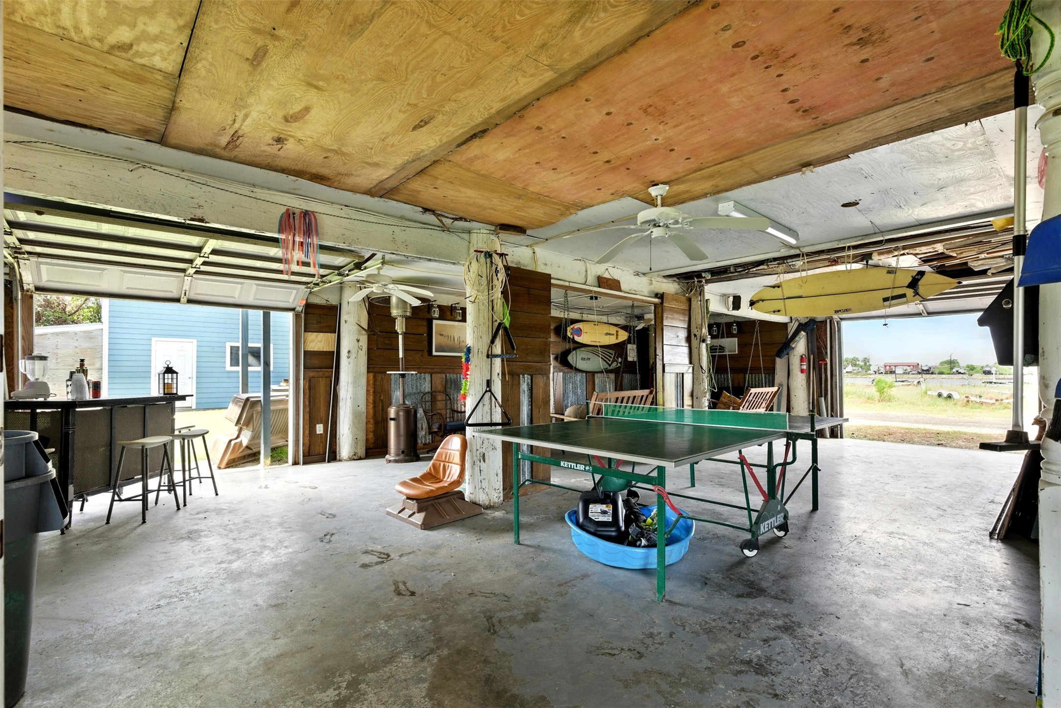 Garage / Party room below the house with concrete floors and 4 garage doors