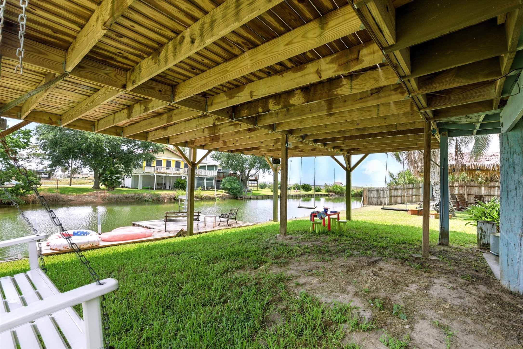 green space under the home with swings and view of the dock