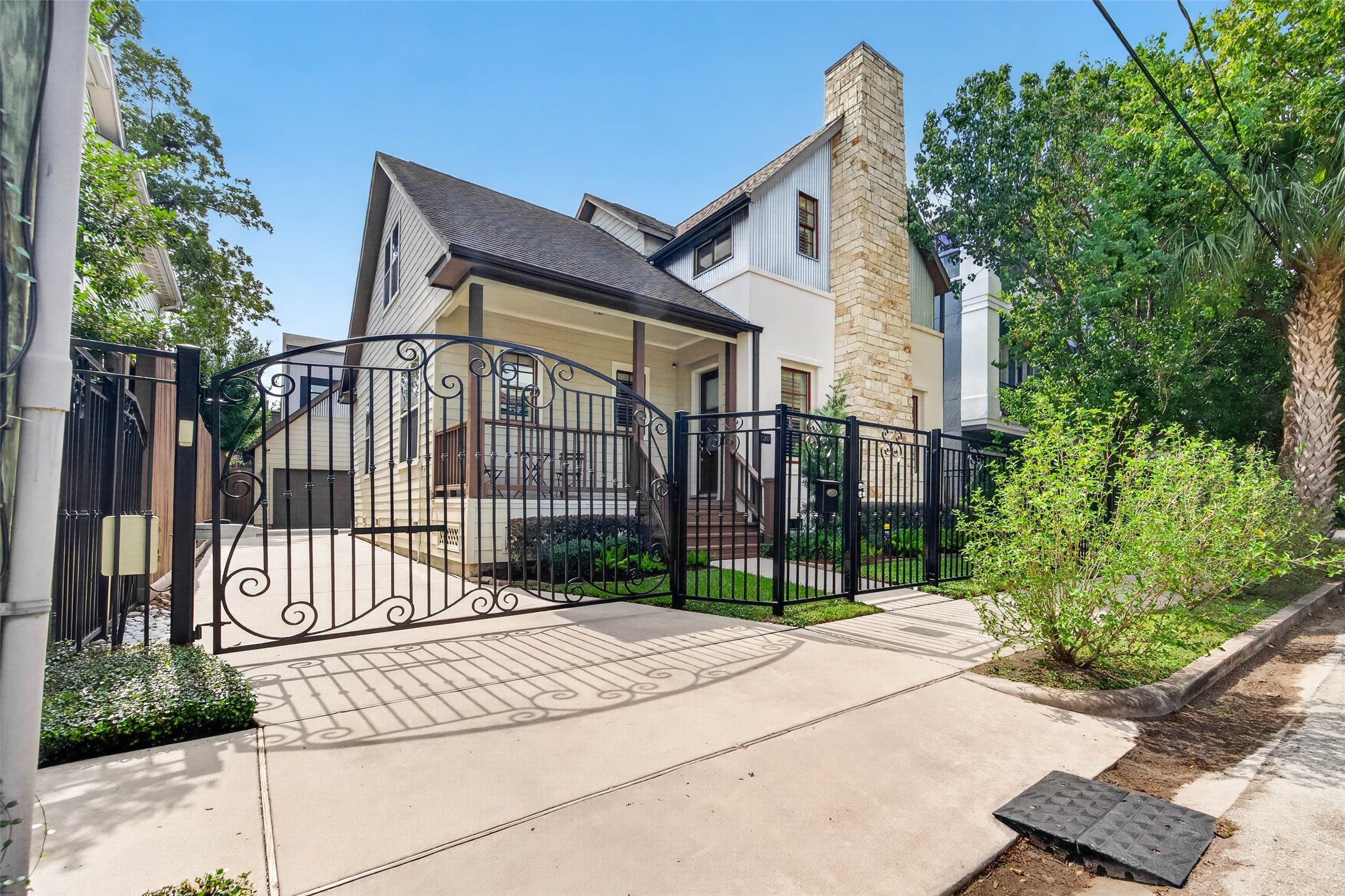 Charming curb appeal with thoughtful details throughout. The classic wrought-iron fence, gated driveway, and separate pedestrian gate offer both character and privacy, while the neatly maintained front garden beds add a touch of greenery and warmth.