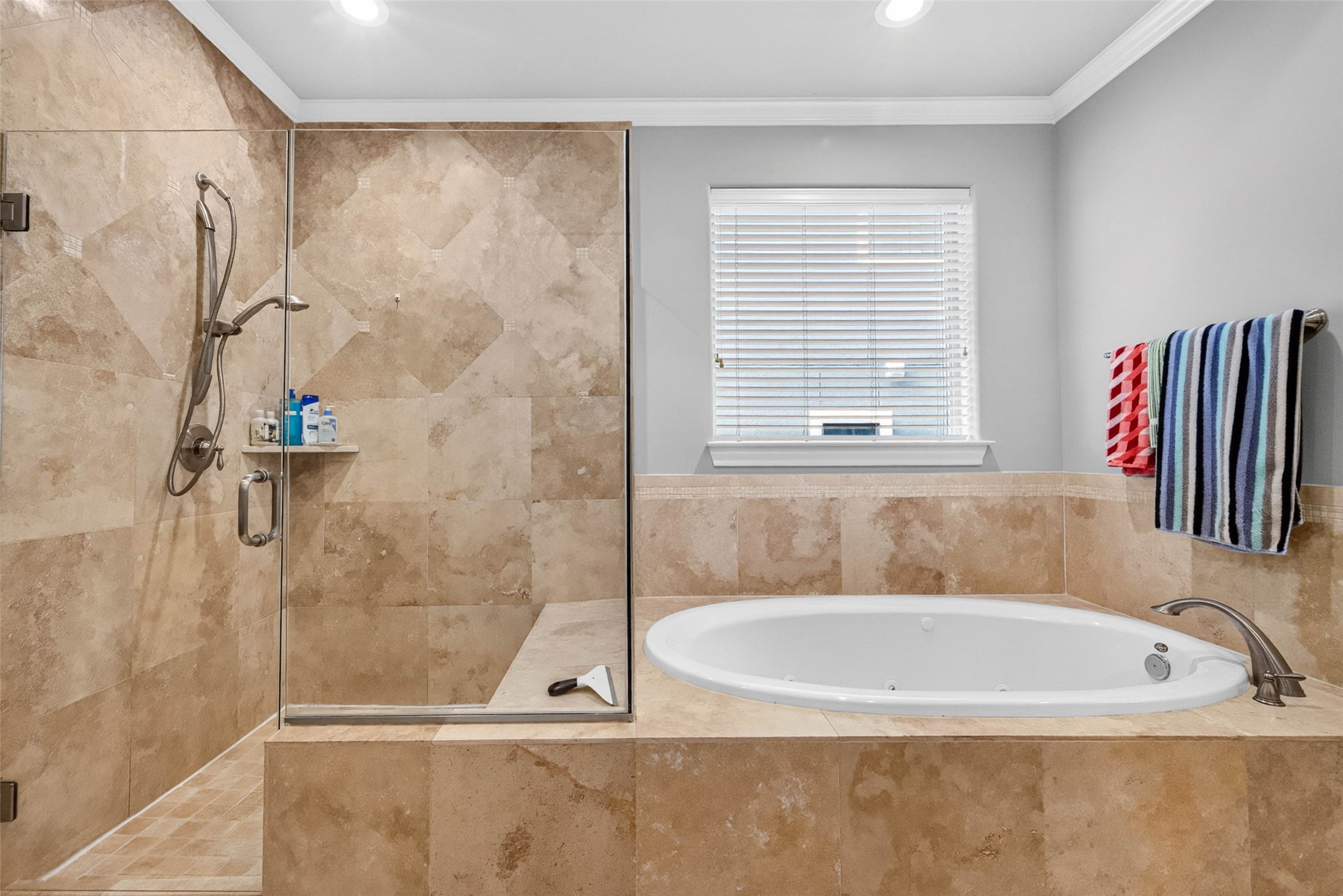 The primary bath features separate vanity areas, a walk-in shower, and a soaking tub for added comfort and convenience.