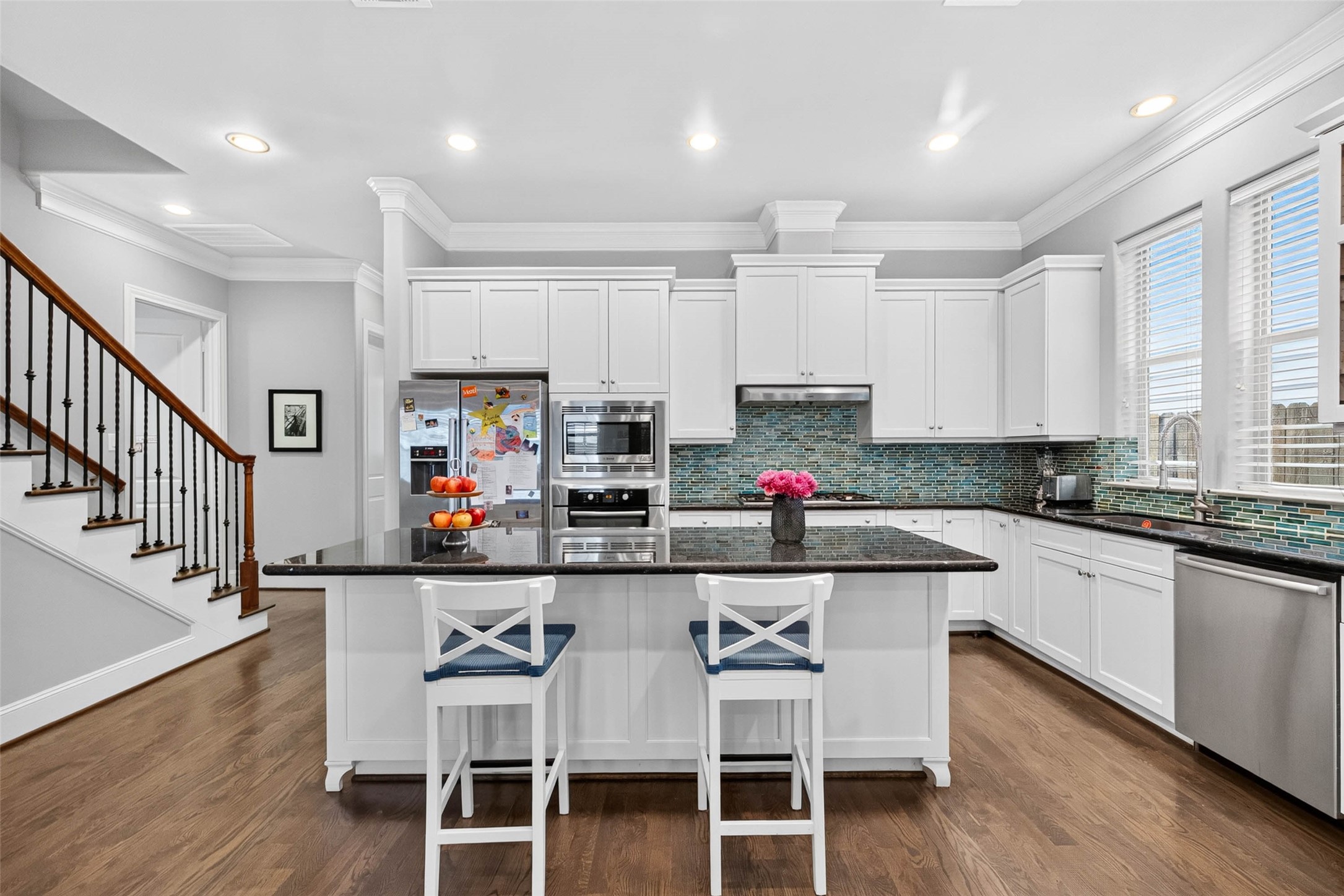 The heart of the home is a well-appointed gourmet kitchen, featuring custom Wood-Mode cabinetry, granite countertops, stainless steel appliances, and a gas range.