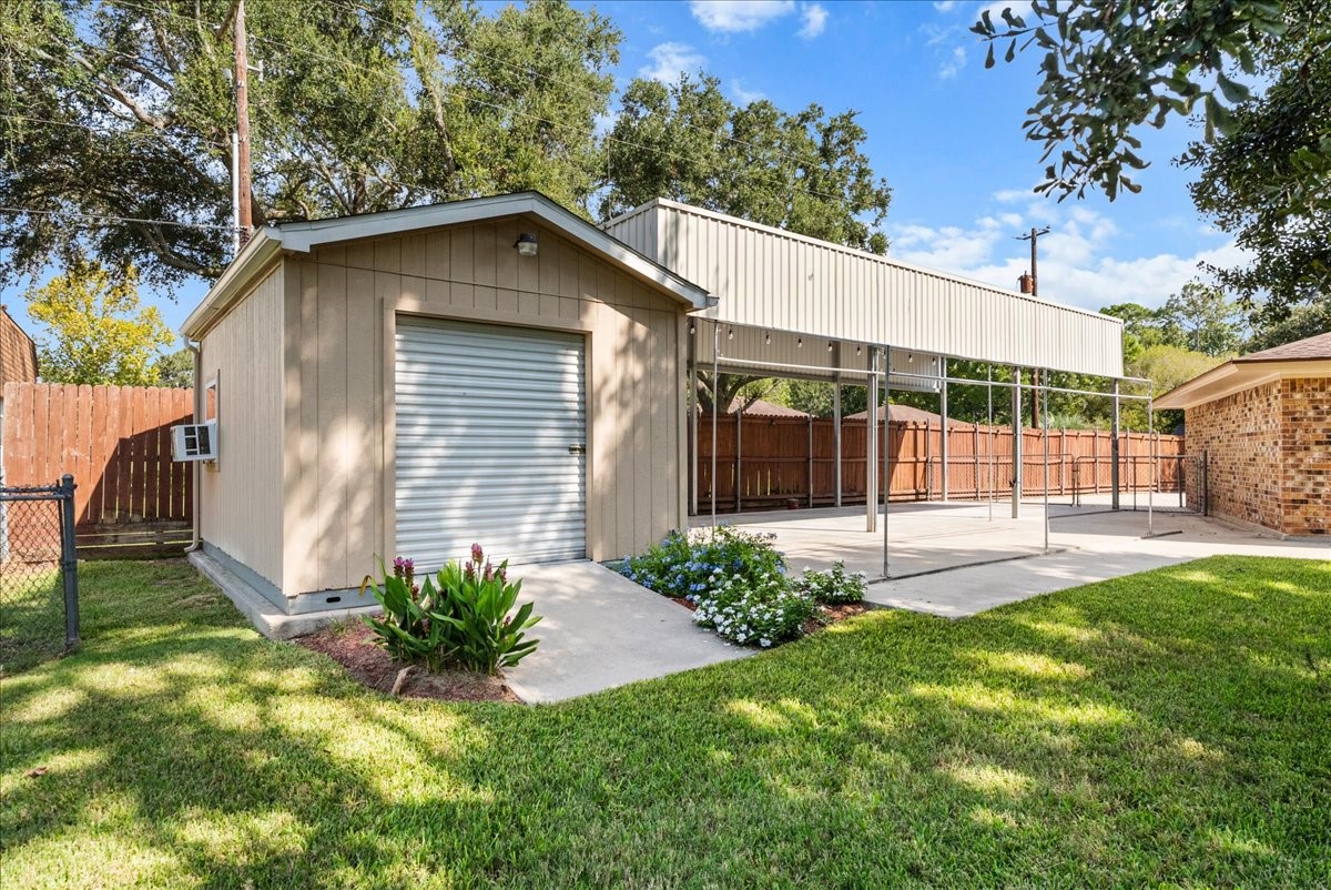 Spacious backyard with a versatile shed and covered carport, ideal for storage or outdoor projects, and a covered parking large enough for an RV.
