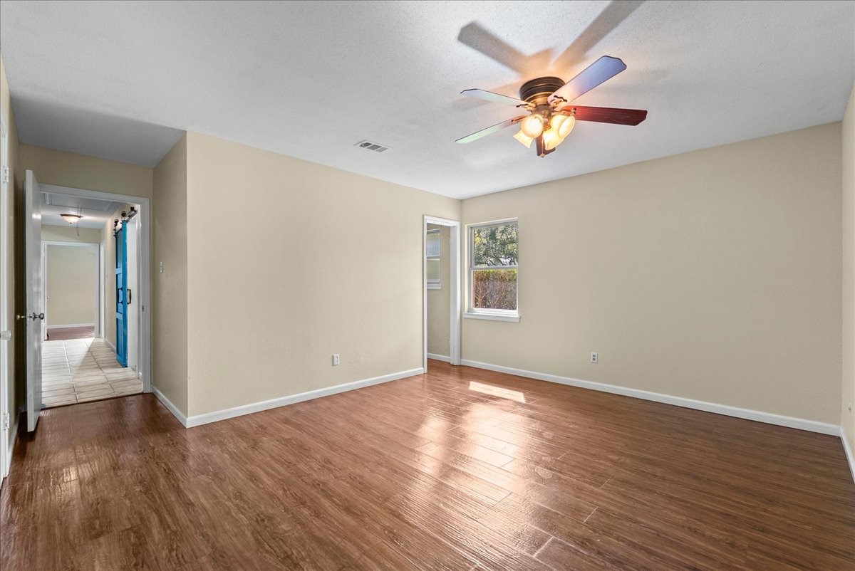 Spacious primary bedroom featuring durable laminate flooring and a private en-suite bathroom for added convenience.