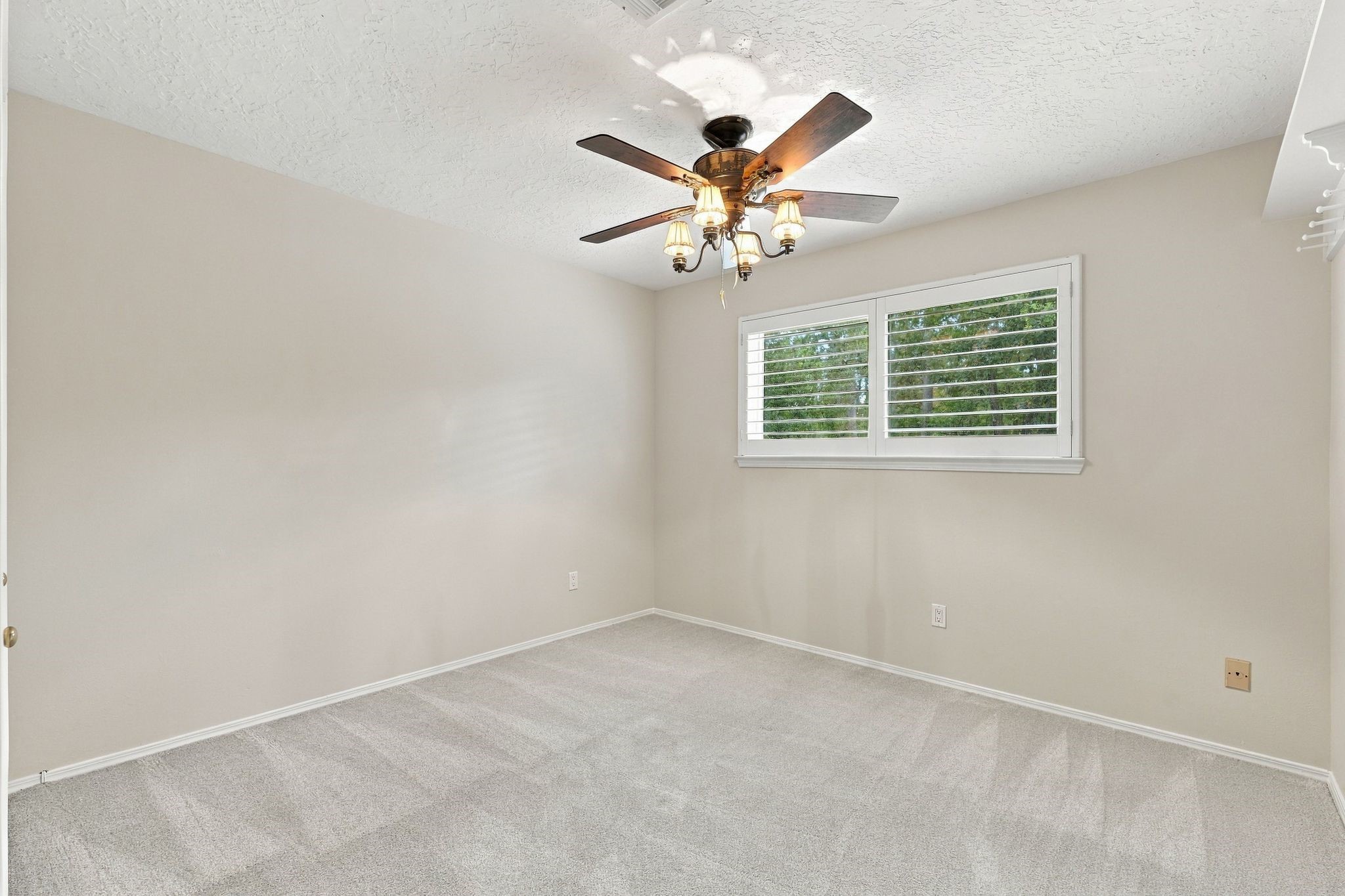 Secondary bedroom with plantation shutters and walk in closet