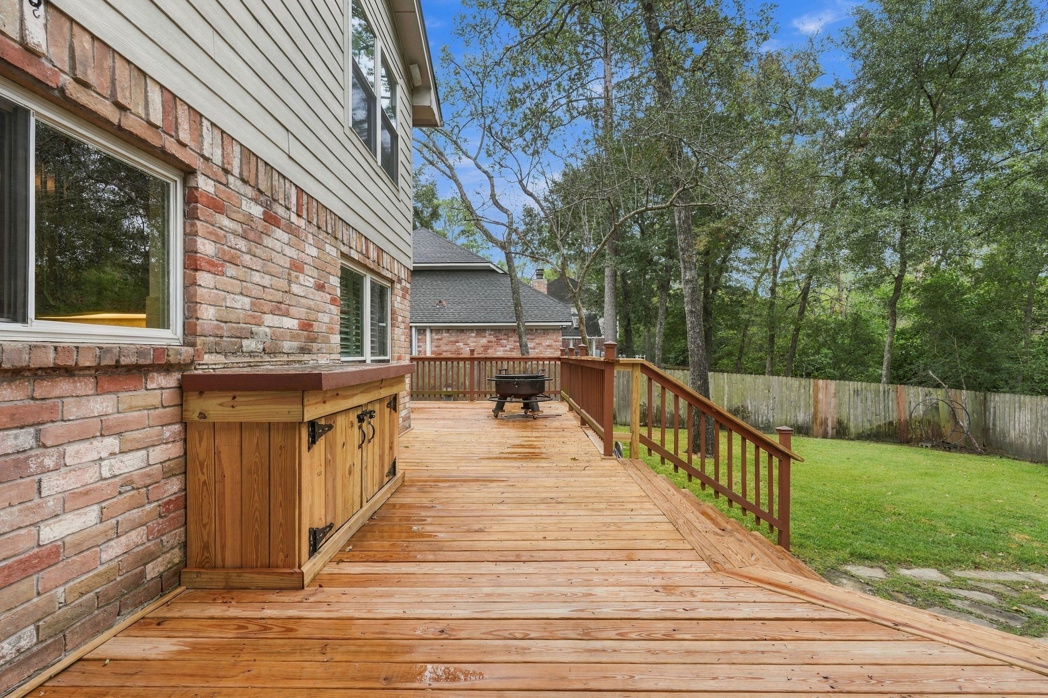 Another angle of the spacious deck, showcasing the open outdoor space and surrounding mature trees.