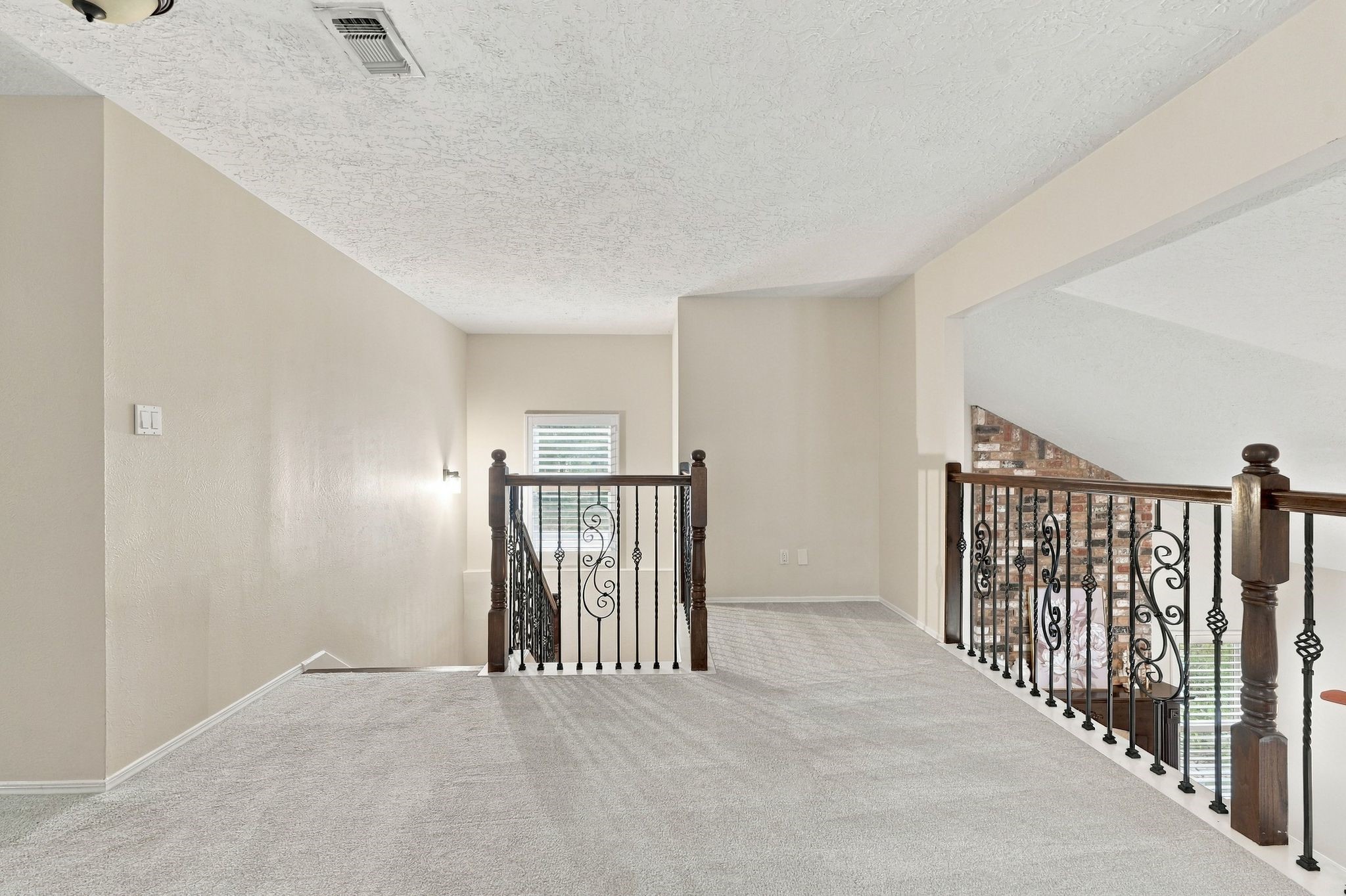 Spacious upstairs loft area with an open layout overlooking the lower level, offering plenty of possibilities for additional living space.