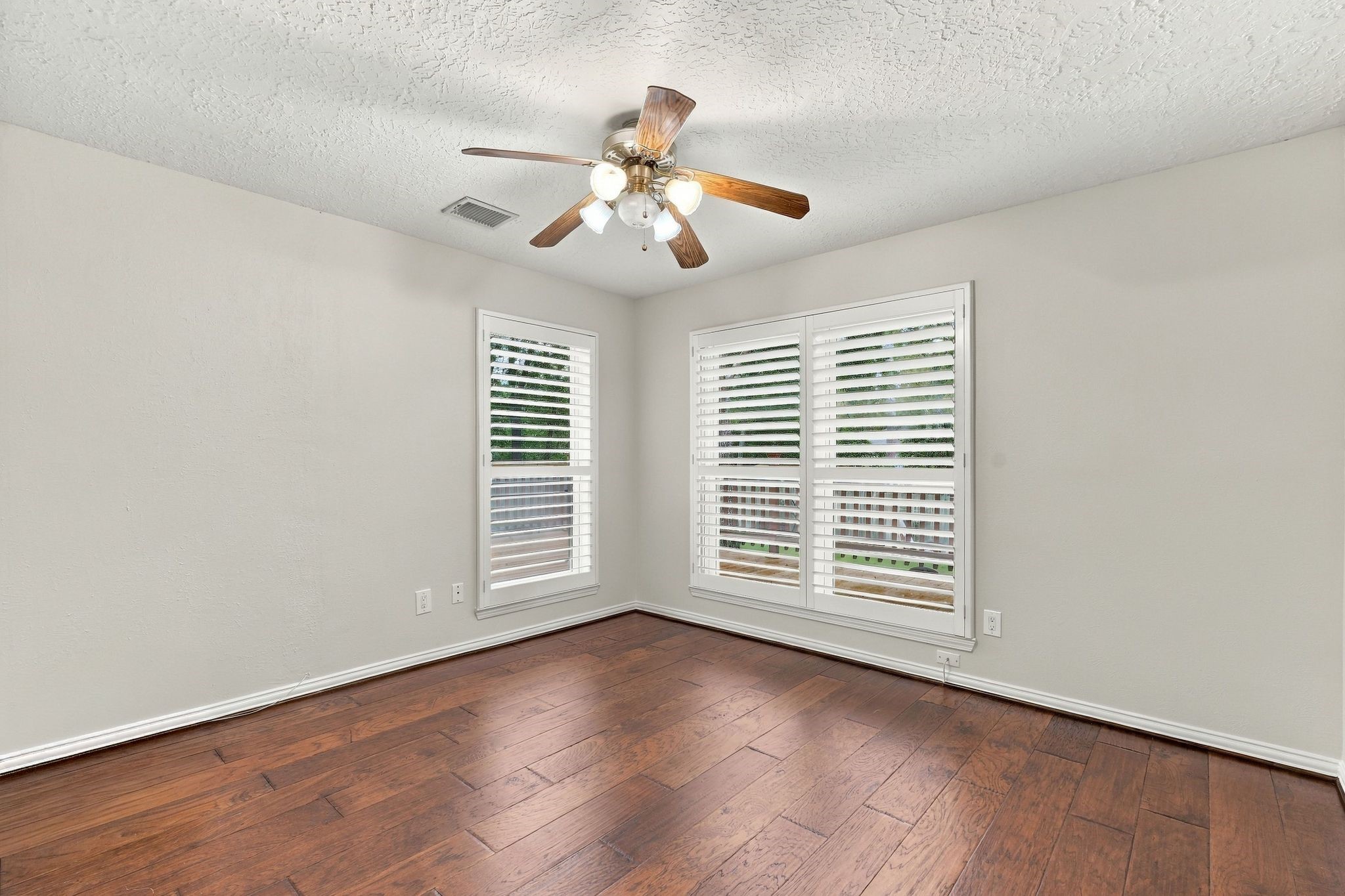 Bright bedroom featuring a ceiling fan, large windows, and plenty of natural light located on first level. This space can be also used as a home office/study.