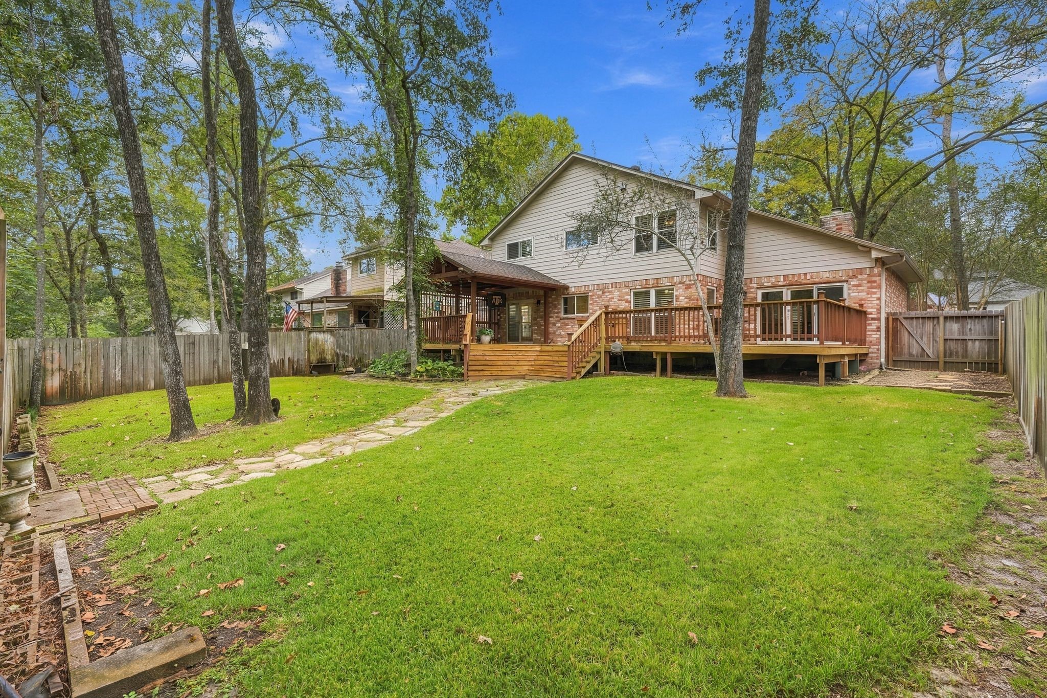 Spacious backyard featuring a large green lawn, mature shade trees, and plenty of room for outdoor activities. Check out the expansive deck! Spacious backyard featuring a large green lawn, mature shade trees, and plenty of room for outdoor activities. Check out the expansive deck!
