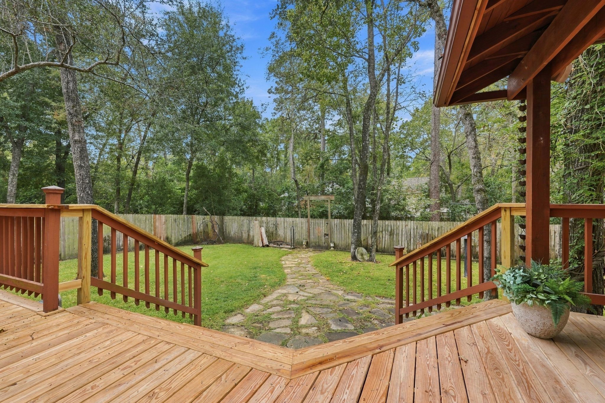 View from the deck overlooking the spacious backyard and peaceful wooded surroundings.