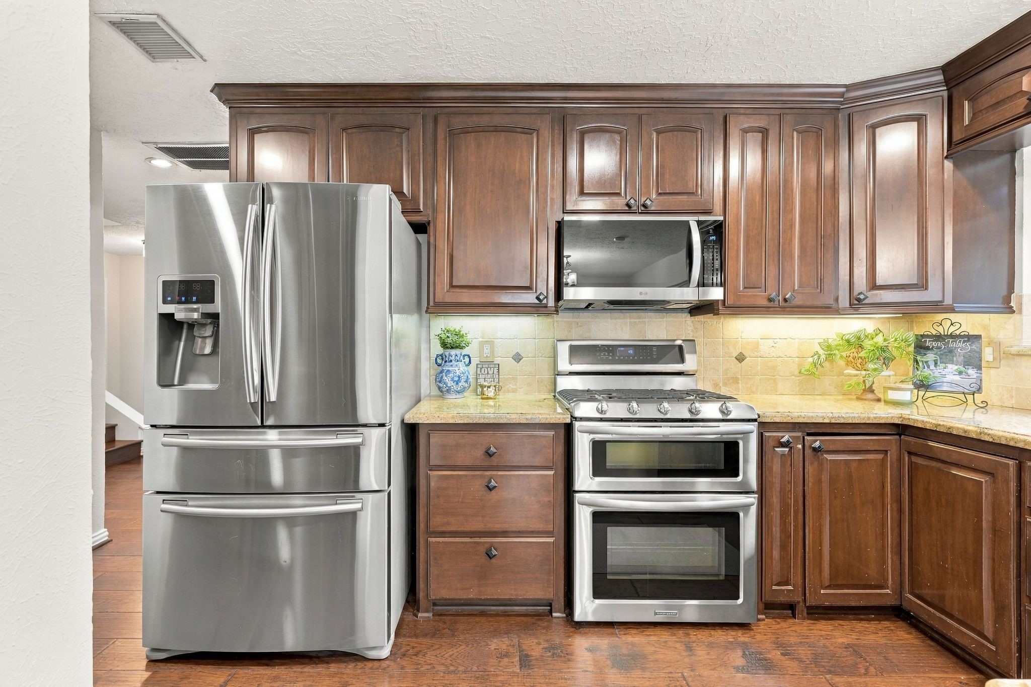 Kitchen featuring rich wood cabinetry, generous granite counter space, and a functional layout. Refrigerator conveys with the home.
