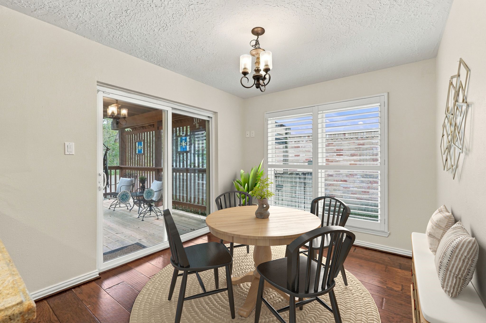Bright dining area featuring large windows and easy access to the covered deck and outdoor space. Virtually staged