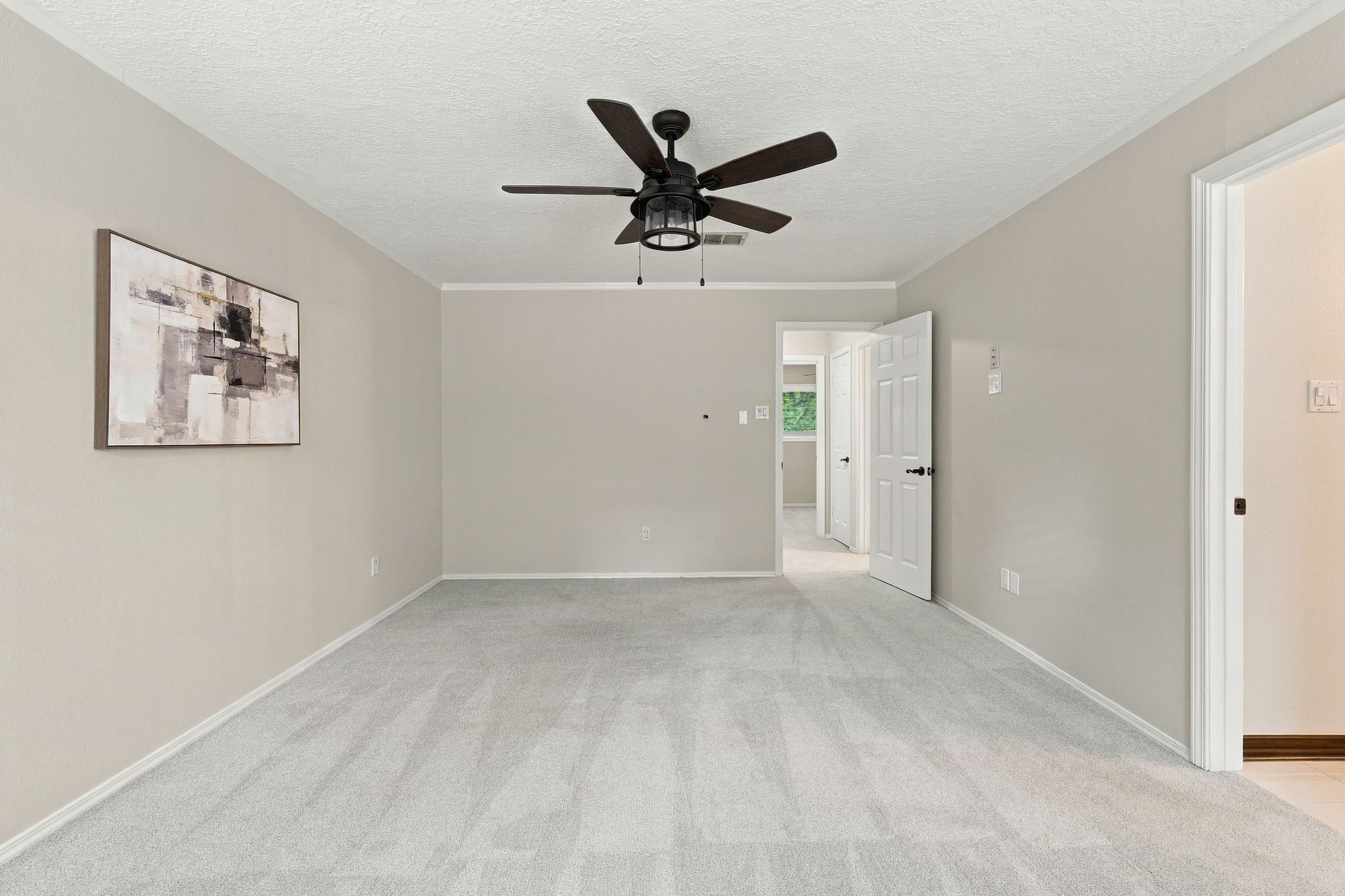 Spacious primary bedroom with a ceiling fan and plenty of room to create your own relaxing retreat.