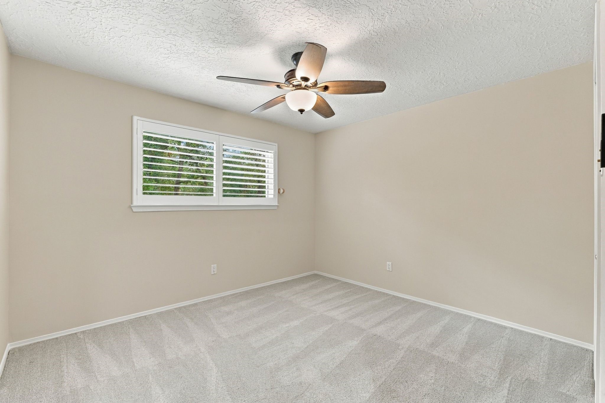 Secondary Bedroom with a ceiling fan and windows overlooking the outdoors and built-ins in the closet.