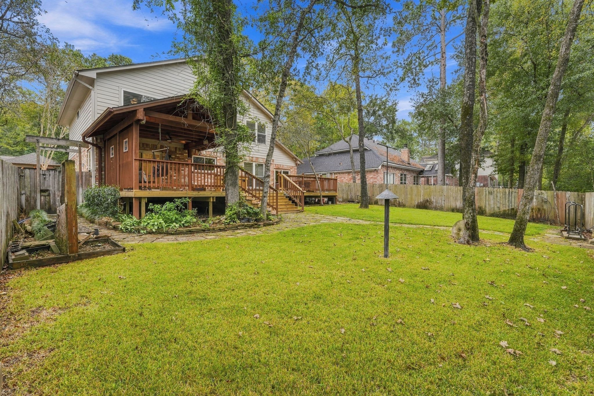 Spacious backyard with mature shade trees and plenty of open green space for outdoor activities.