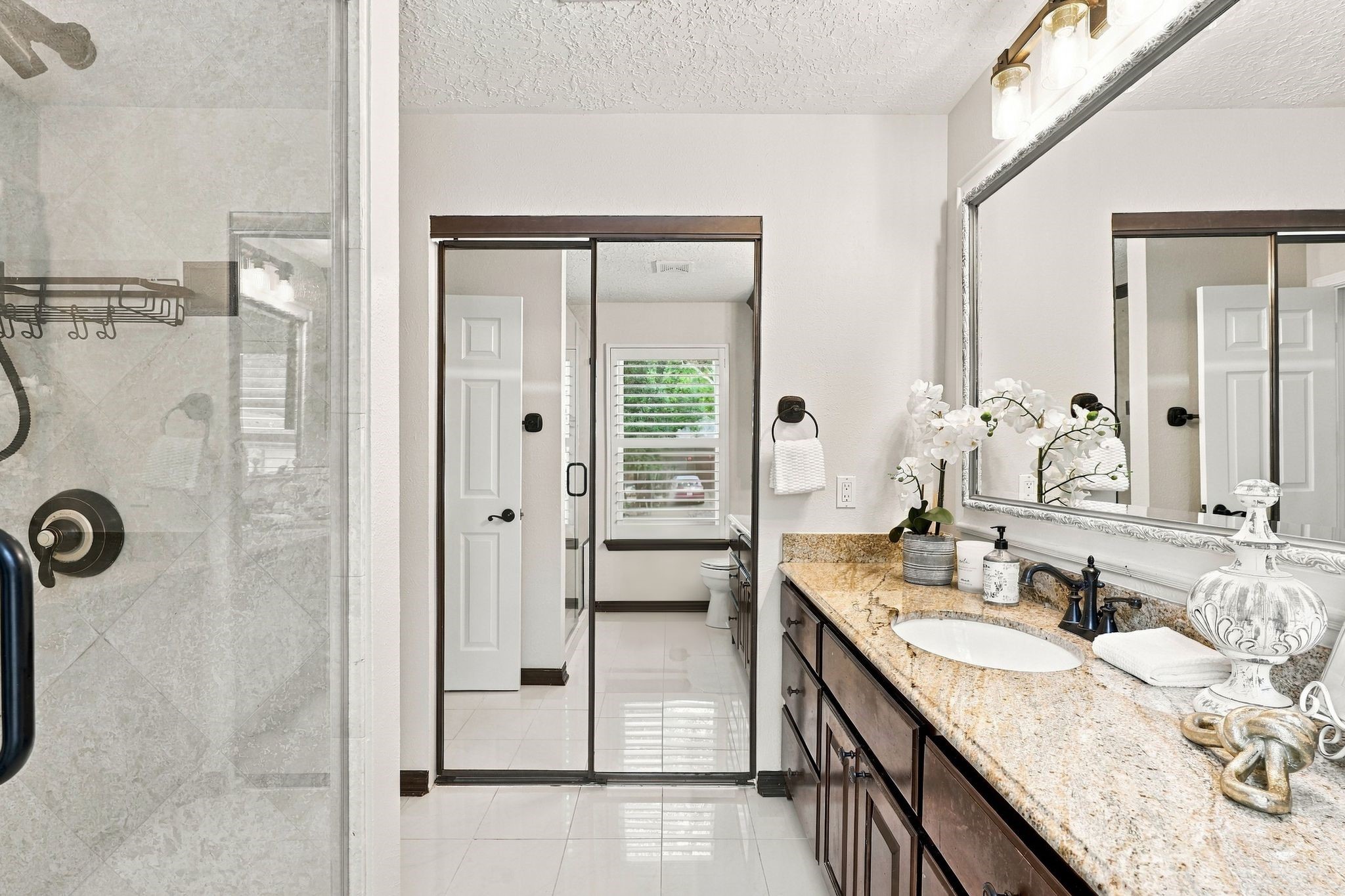Another view of the primary bathroom. Primary closet with built-ins behind the mirrored doors.