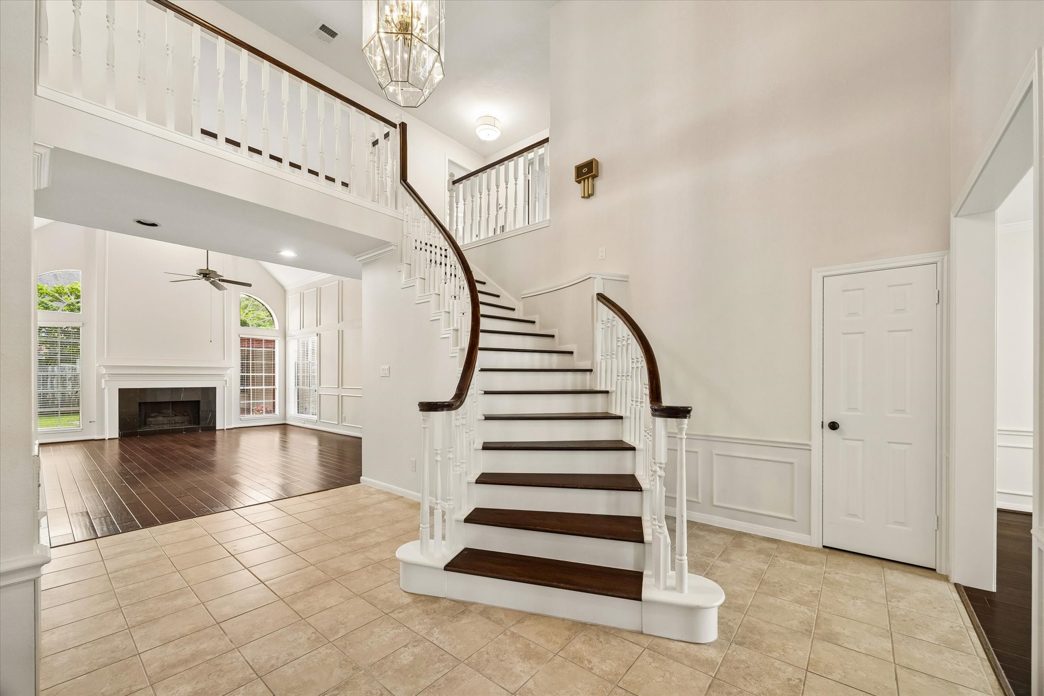 GRAND TWO-STORY FOYER WITH A SWEEPING STAIRCASE, SOARING CEILINGS, AND AN OPEN VIEW INTO THE LIGHT-FILLED FAMILY ROOM.